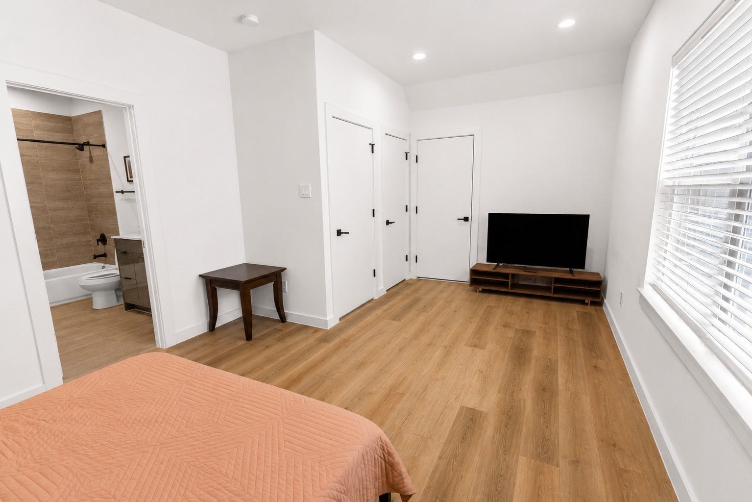 Expansive third floor bedroom offers exceptional flexibility with enough room for oversized furniture, a home office, workout area, or private guest retreat. Vaulted ceilings and large windows enhance the open feel while maintaining privacy from the main living spaces above.