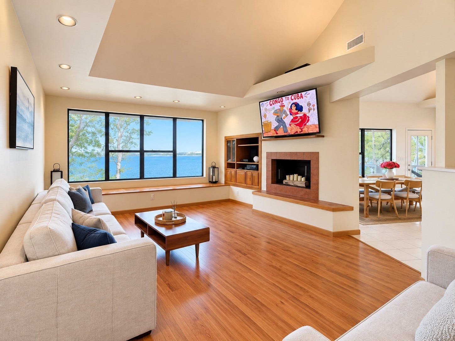 4207 Tri City Beach Road, Baytown, TX 77523 Spacious living room with stunning lake views, featuring a cozy fireplace, elegant hardwood floors, and an open layout connecting to the dining area.