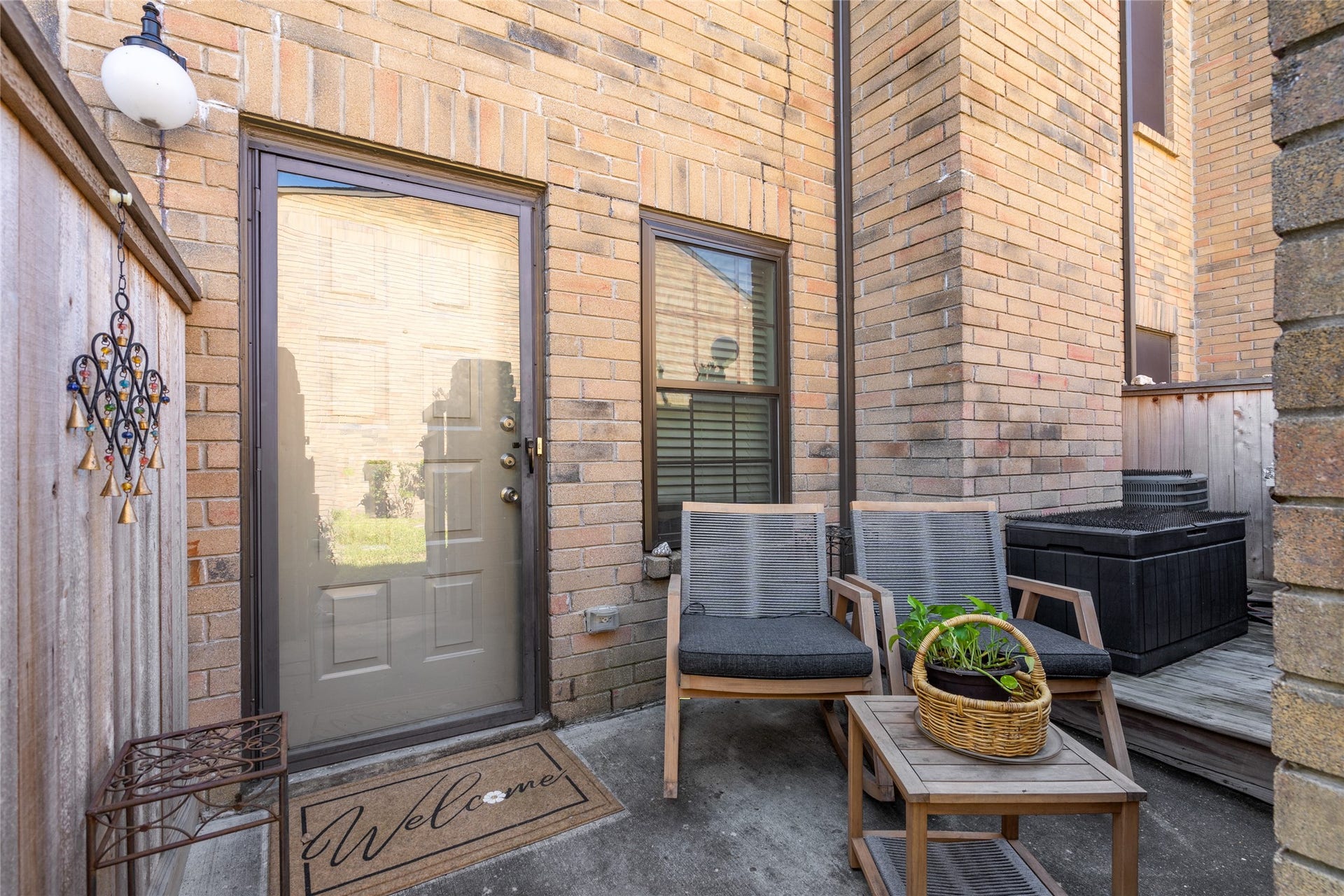 9850 Pagewood Lane, #1302, Houston, TX 77042 Charming and private, this inviting front patio offers the perfect space to enjoy your morning coffee or unwind in the fresh air. Featuring a cozy seating area, stylish brick exterior, and a welcoming glass door entry, this space sets the tone for comfortable living. A touch of greenery and decorative accents add to the warm and inviting ambiance.
