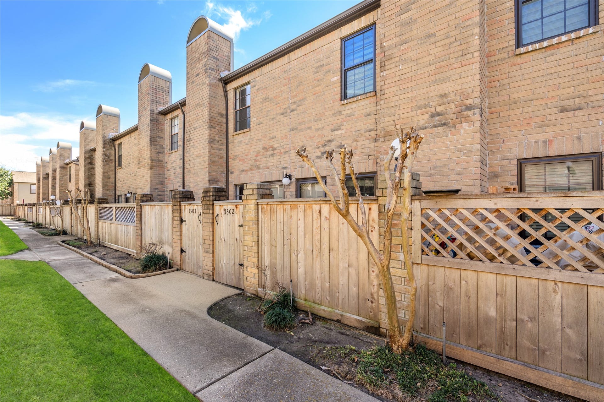 9850 Pagewood Lane, #1302, Houston, TX 77042 Nestled in a well-maintained community, 9850 Pagewood Lane #1302 offers a charming townhome with a classic brick faade and a private gated entrance. A beautifully landscaped walkway leads to the front patio, providing a peaceful retreat. The striking row of chimneys adds architectural character, while the wooden fence ensures privacy. Enjoy the blend of convenience and charm in this inviting space.