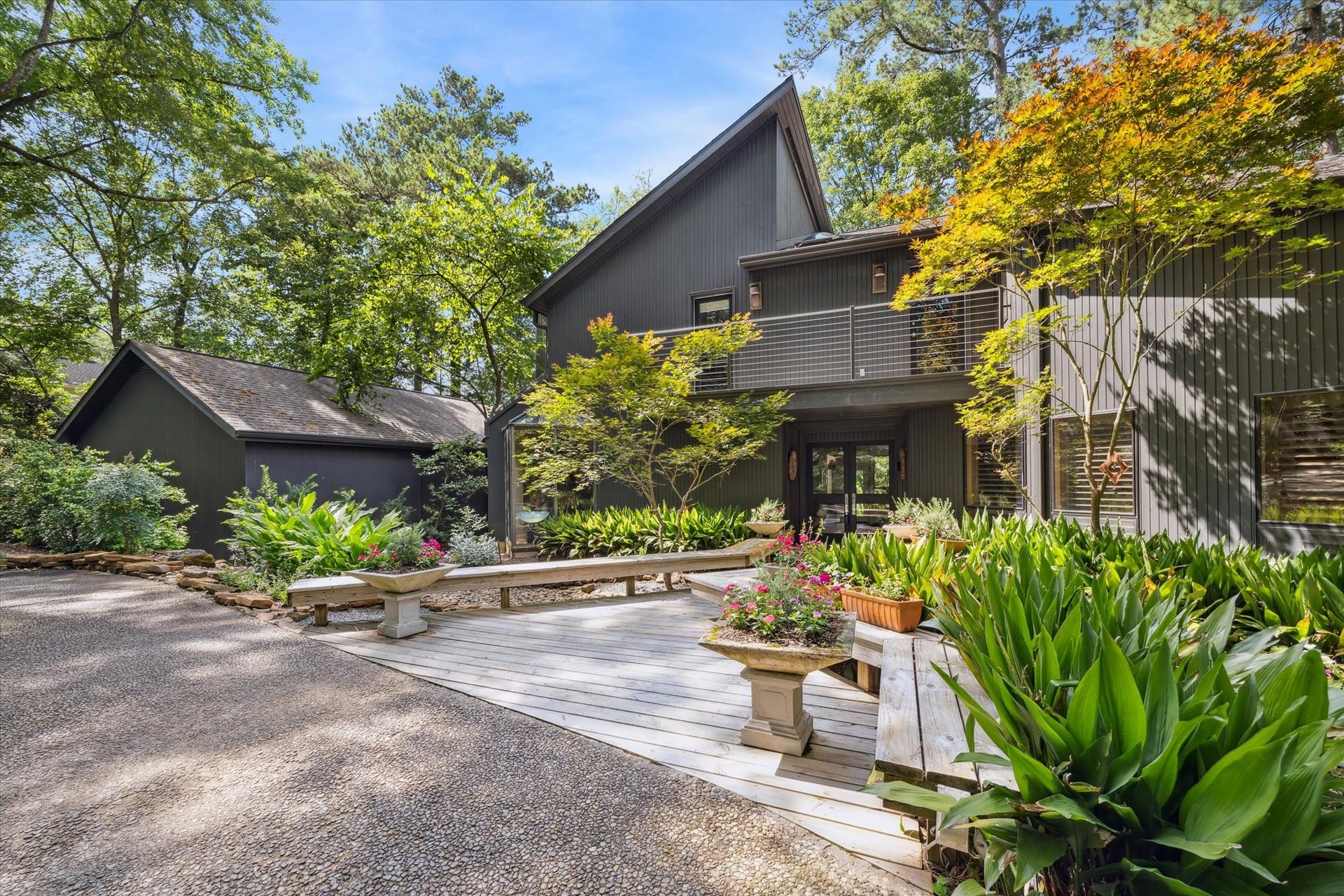 23414 Holly Hollow Street, Tomball, TX 77377 Lush landscaping, mature plantings, and a serene courtyard approach create a warm and inviting arrival. This unique property combines modern design with a peaceful retreat-like atmosphere, offering both style and privacy in a natural setting.