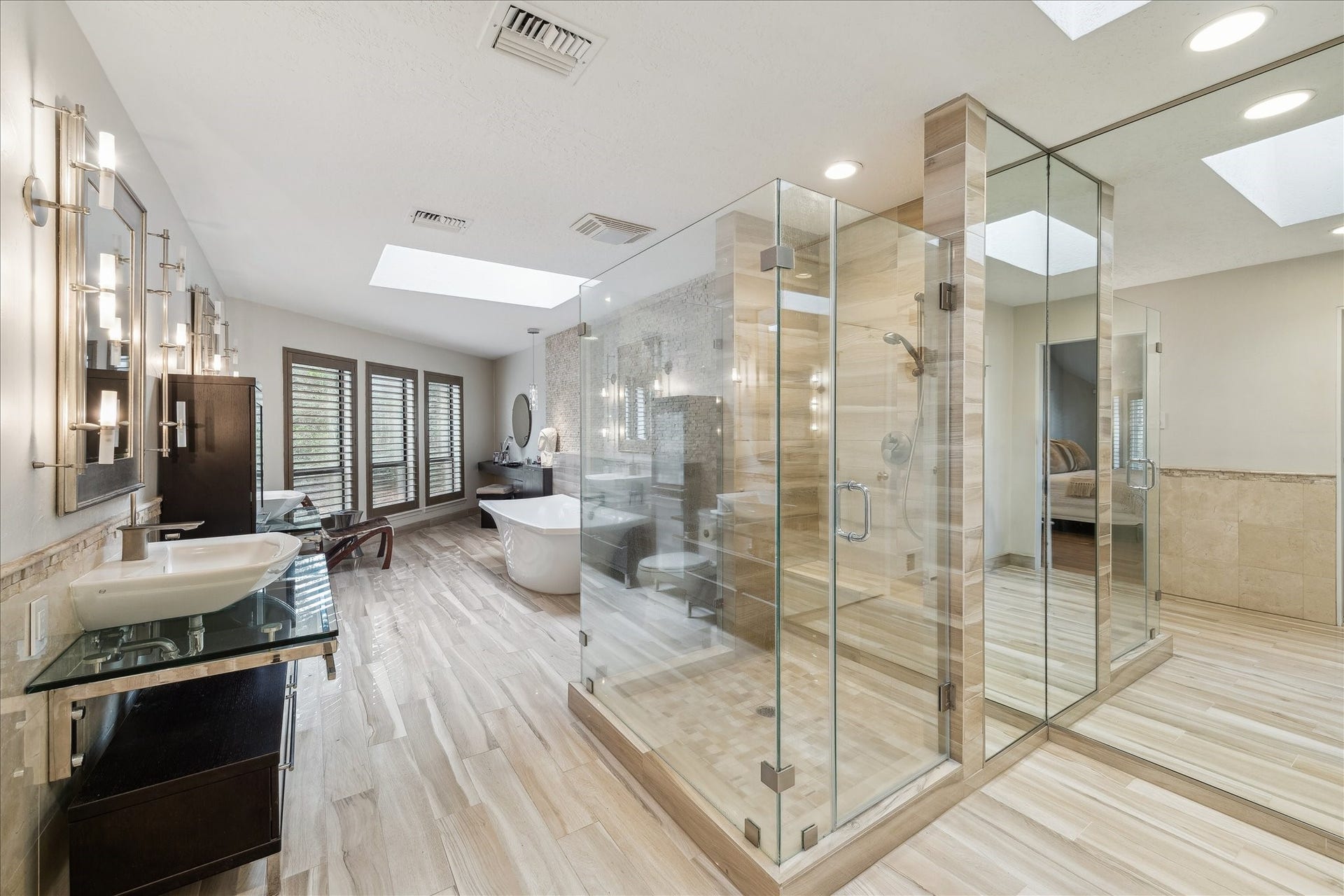 23414 Holly Hollow Street, Tomball, TX 77377 Skylights illuminate its luxurious ensuite, featuring a frameless glass shower and a deep soaking tub where you can unwind beneath the sunlight or stars.