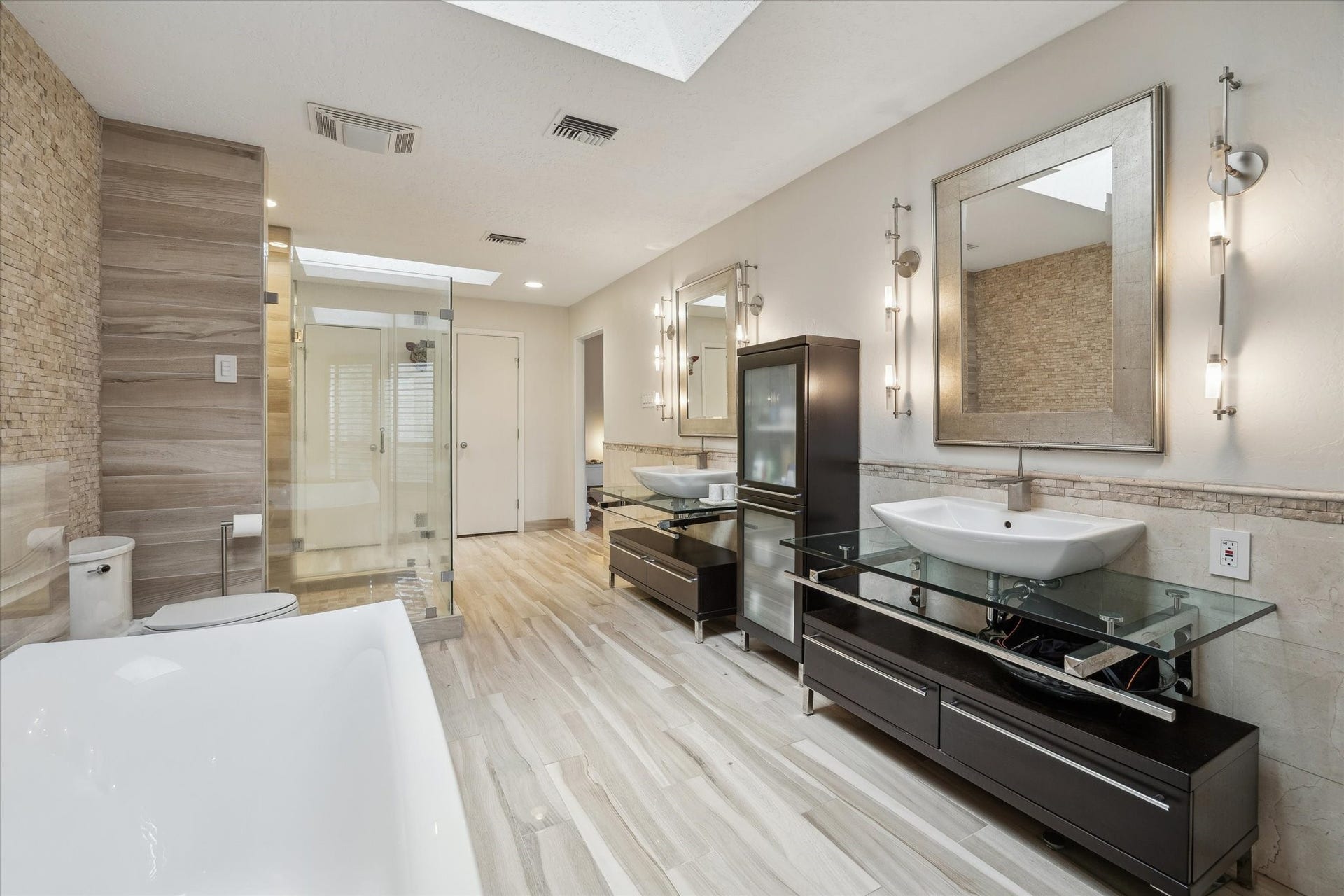 23414 Holly Hollow Street, Tomball, TX 77377 This ultra-luxe ensuite bath evokes a private spa experience, featuring dual vanities, soaking tub and a seamless glass shower; enhanced by natural light and a tranquil, elevated ambiance.
