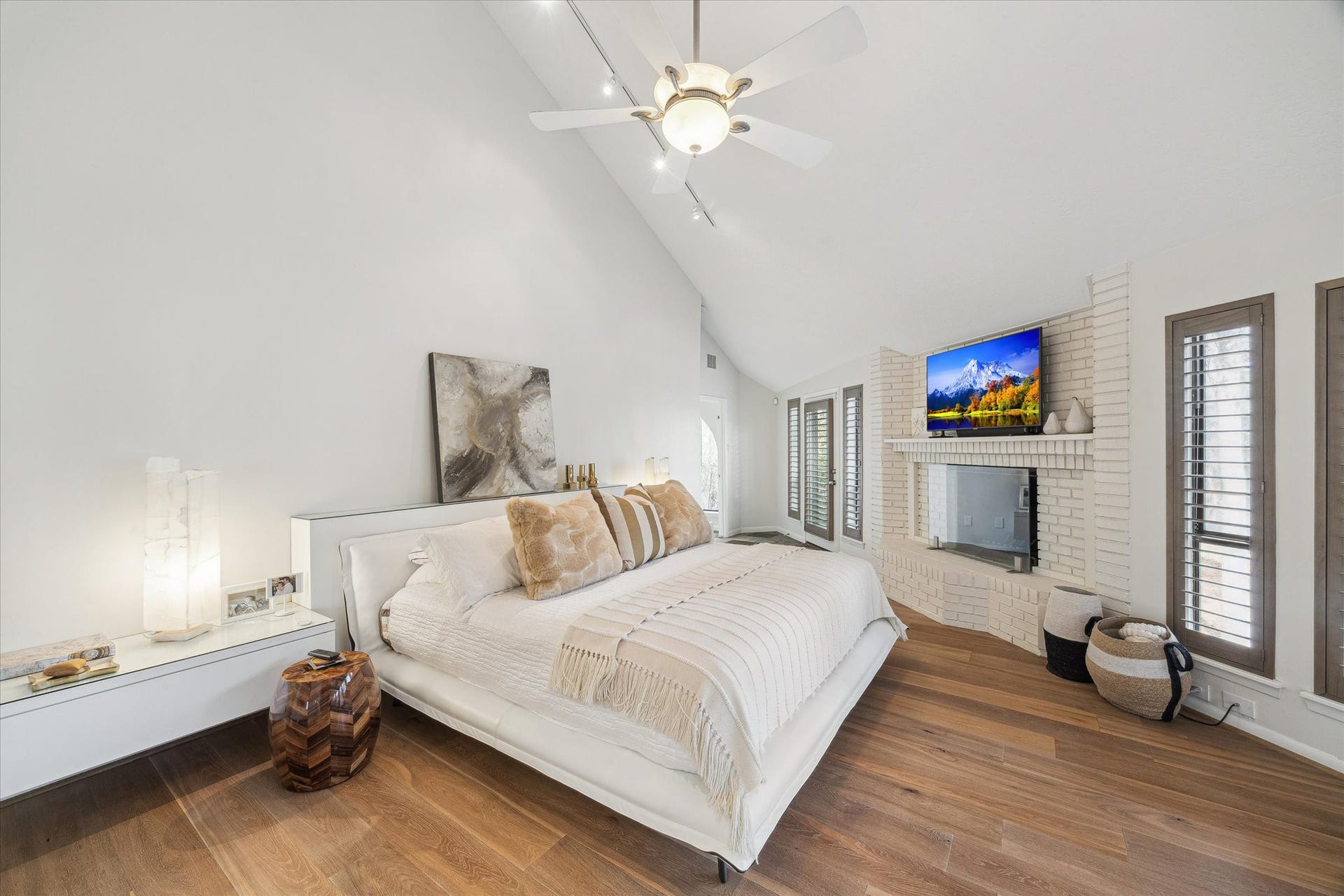 23414 Holly Hollow Street, Tomball, TX 77377 The raised primary suite offers a tranquil and elegant retreat, defined by vaulted ceilings and a private brick hearth that create an intimate sense of comfort and refinement.