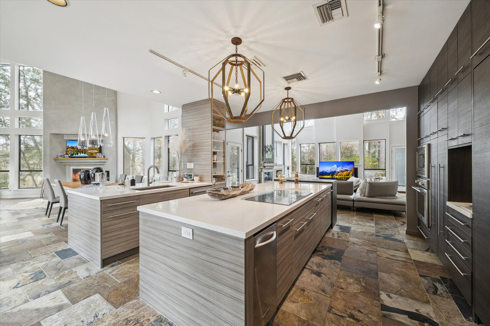 23414 Holly Hollow Street, Tomball, TX 77377 Sleek, modern kitchen designed for both functionality and style, featuring custom flat-panel cabinetry, Thermador appliances, and expansive Quartzite countertops.