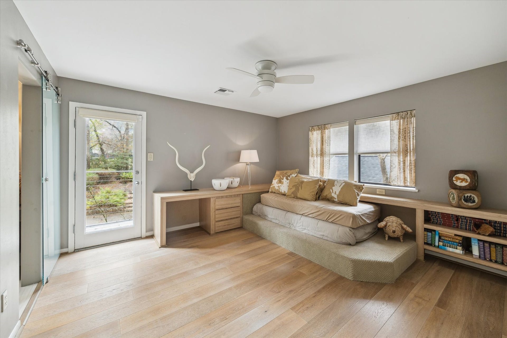 23414 Holly Hollow Street, Tomball, TX 77377 A thoughtfully designed secondary bedroom with an original built-in bed and balcony access, providing both cozy comfort and elevated views of the propertys lush surroundings.
