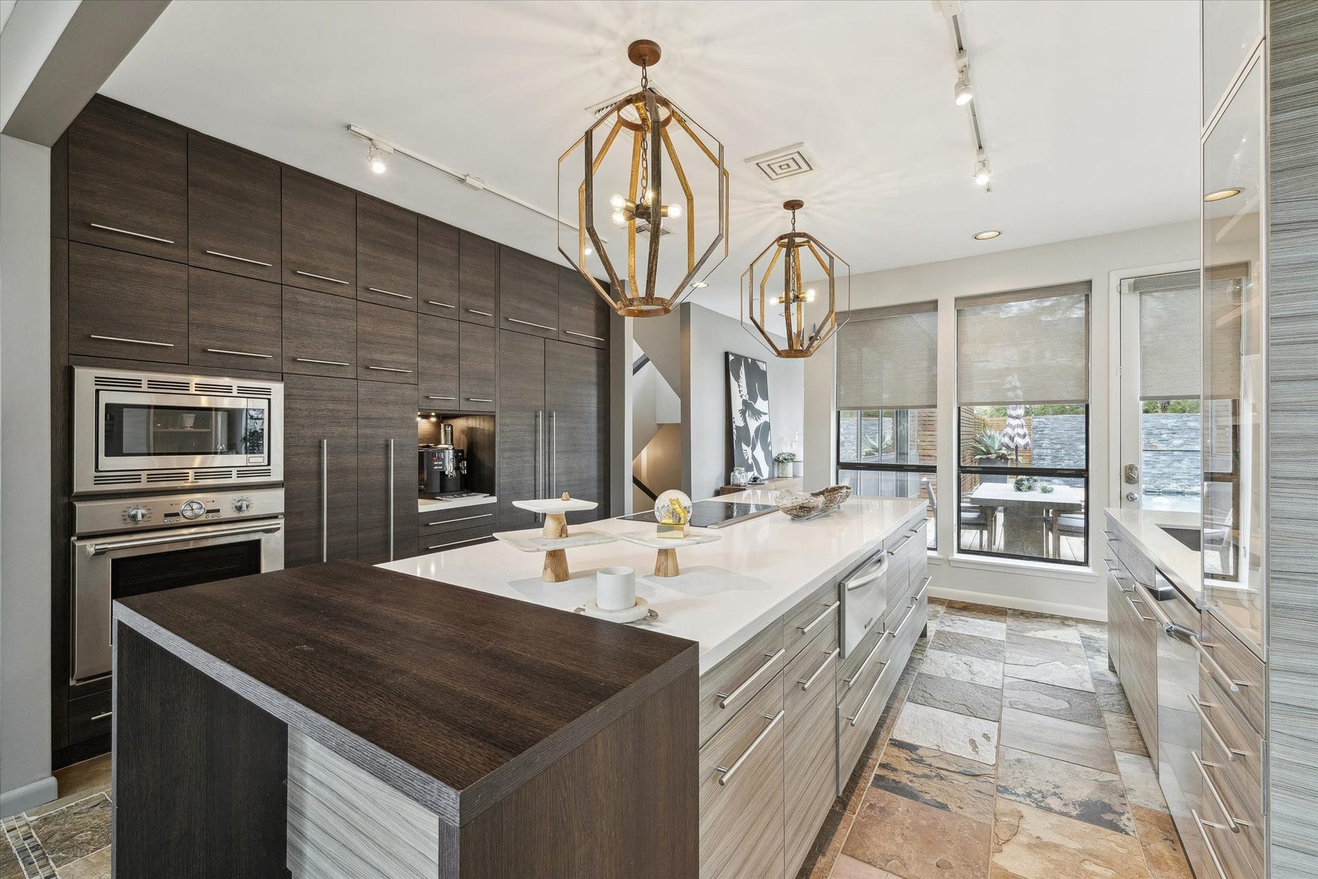 23414 Holly Hollow Street, Tomball, TX 77377 The kitchen flows seamlessly to the adjacent dining area and outdoor space through oversized windows, filling the room with natural light and creating an effortless indoor-outdoor connection.