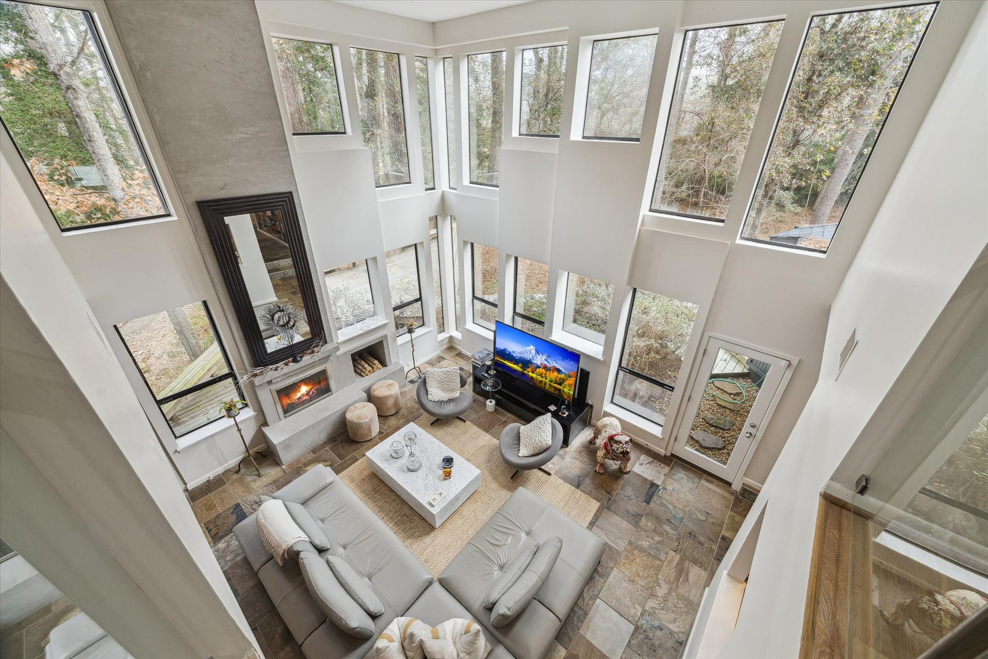 23414 Holly Hollow Street, Tomball, TX 77377 The loft office provides a unique perspective of the living room below, combining openness, natural light, and the tranquil feeling of treetop living.