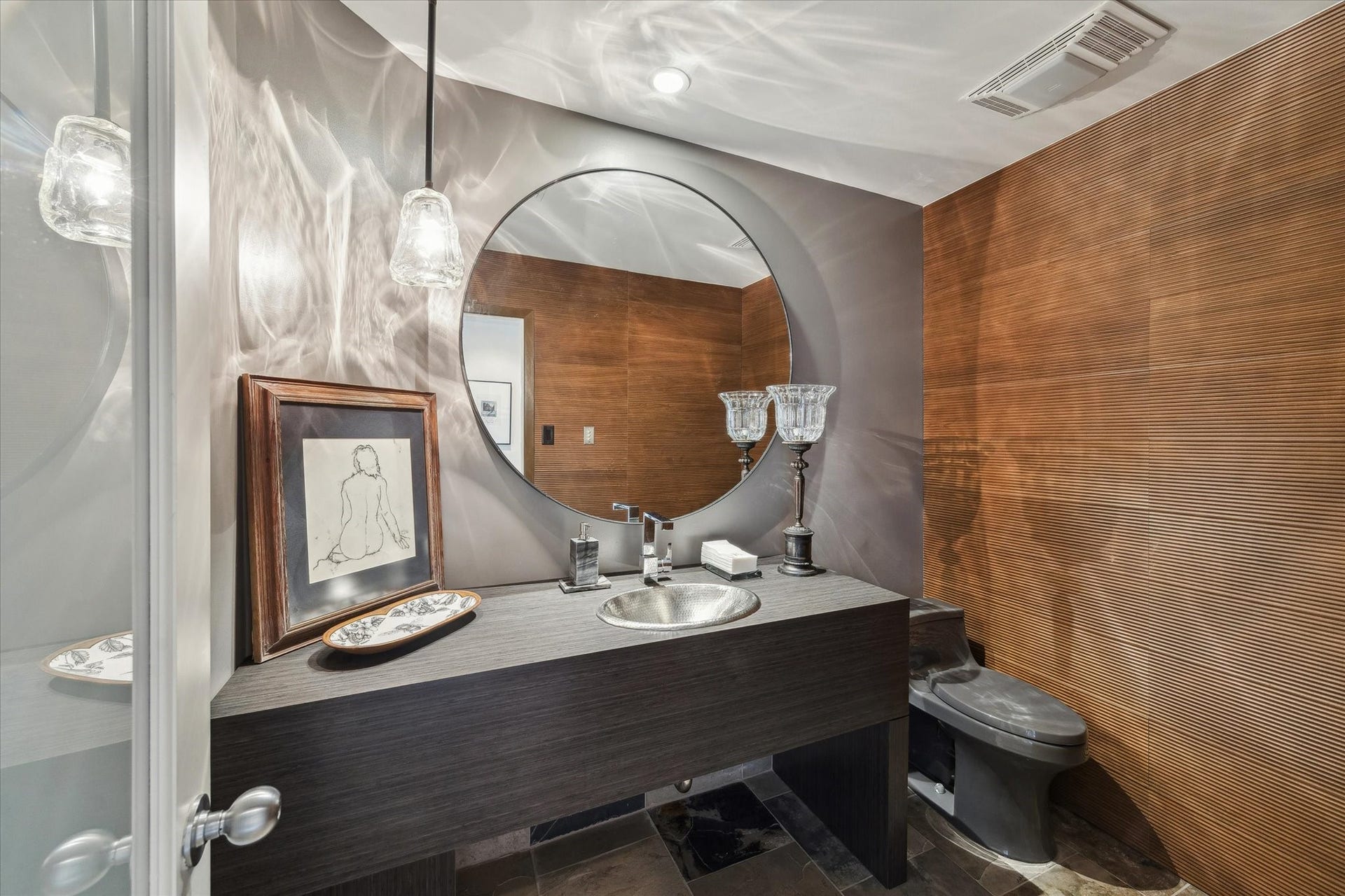 23414 Holly Hollow Street, Tomball, TX 77377 A stylish powder room that reflects the homes attention to detail featuring warm wood accents that tie seamlessly into the surrounding natural landscape. The vanity mirror is excluded.