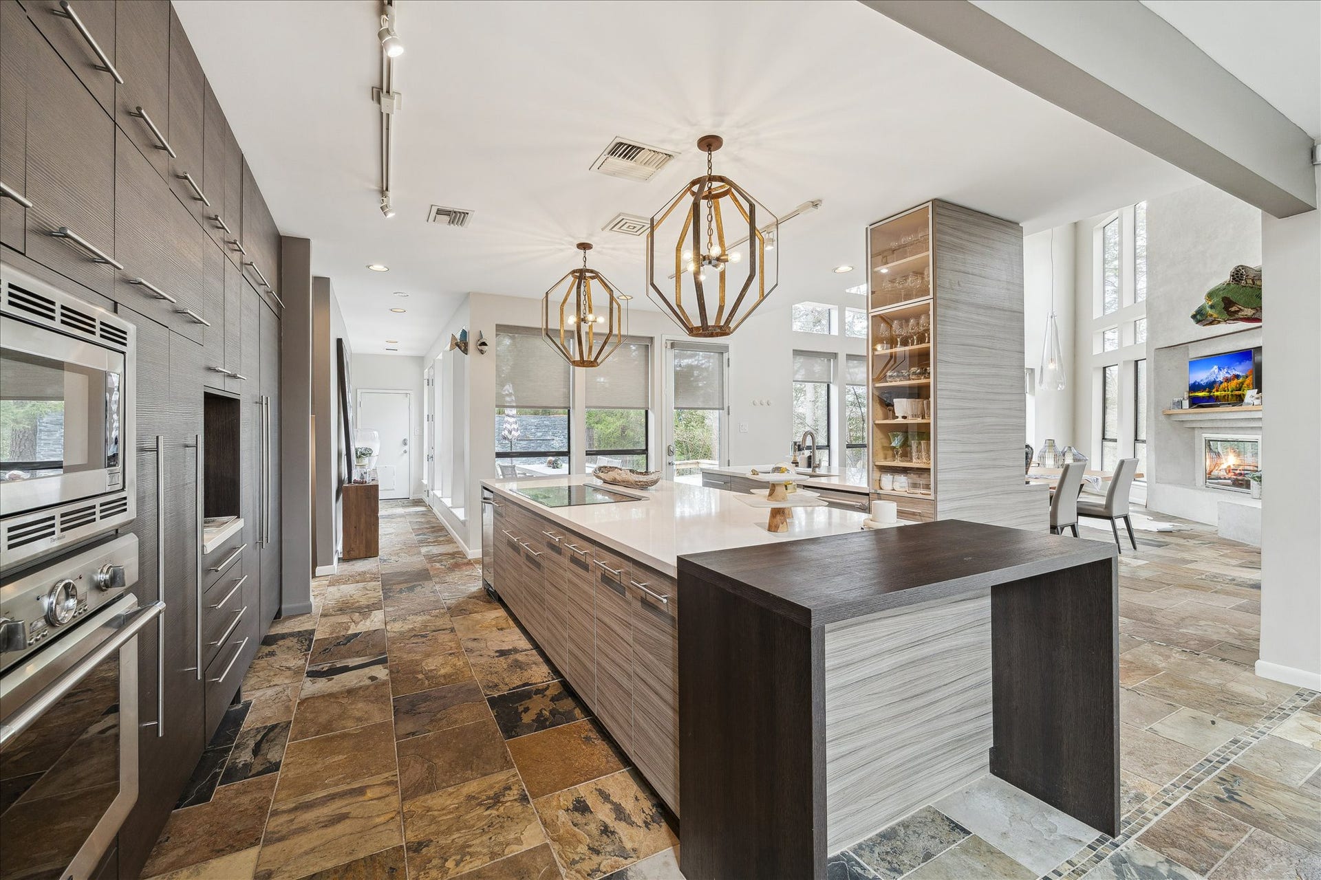 23414 Holly Hollow Street, Tomball, TX 77377 A large center island provides ample workspace and storage, ideal for entertaining and everyday use. Designer pendant lighting and track lighting add architectural interest, while floor-to-ceiling cabinetry offers abundant storage.