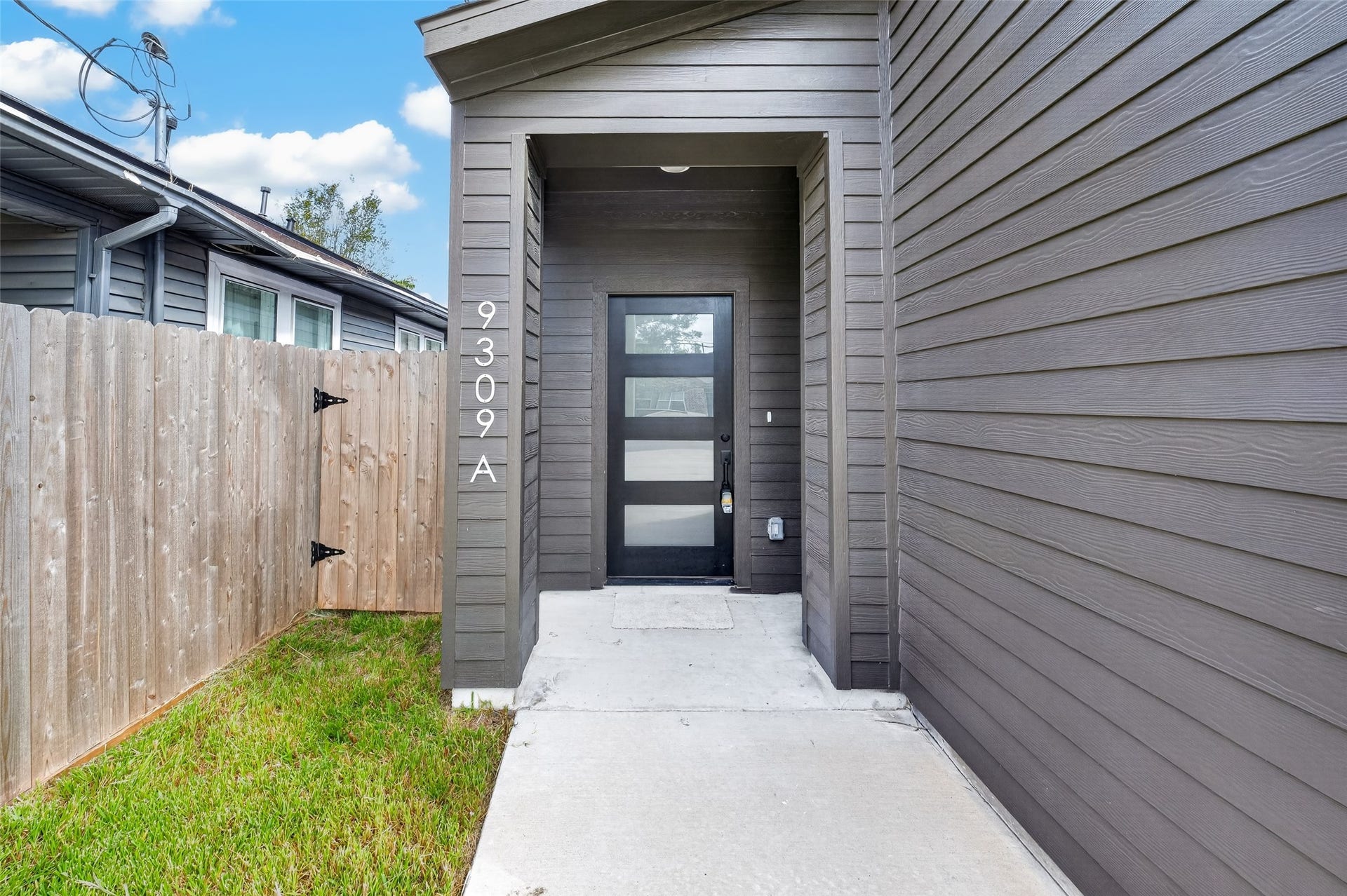 9309 Caddo Road, #A, Houston, TX 77078 Welcome to Unit A! Step up to a private, covered entrance featuring crisp modern siding and a contemporary glass-paneled front door that invites warm, natural light in while setting a sophisticated tone right from the start.