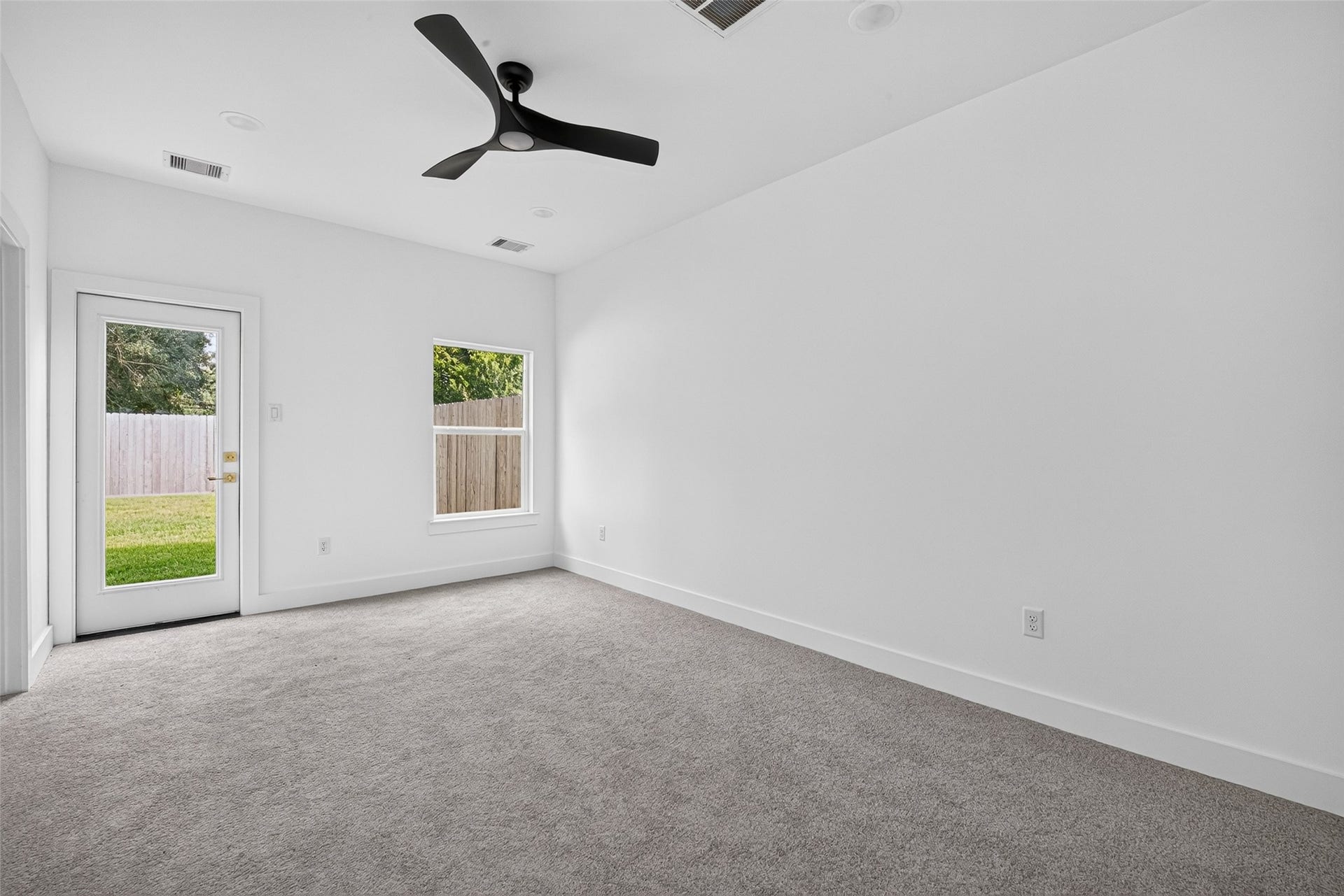 9309 Caddo Road, #A, Houston, TX 77078 our private main suite retreat. Featuring plush carpet, a stylish modern ceiling fan, and direct glass-door access to step out into your peaceful backyard.
