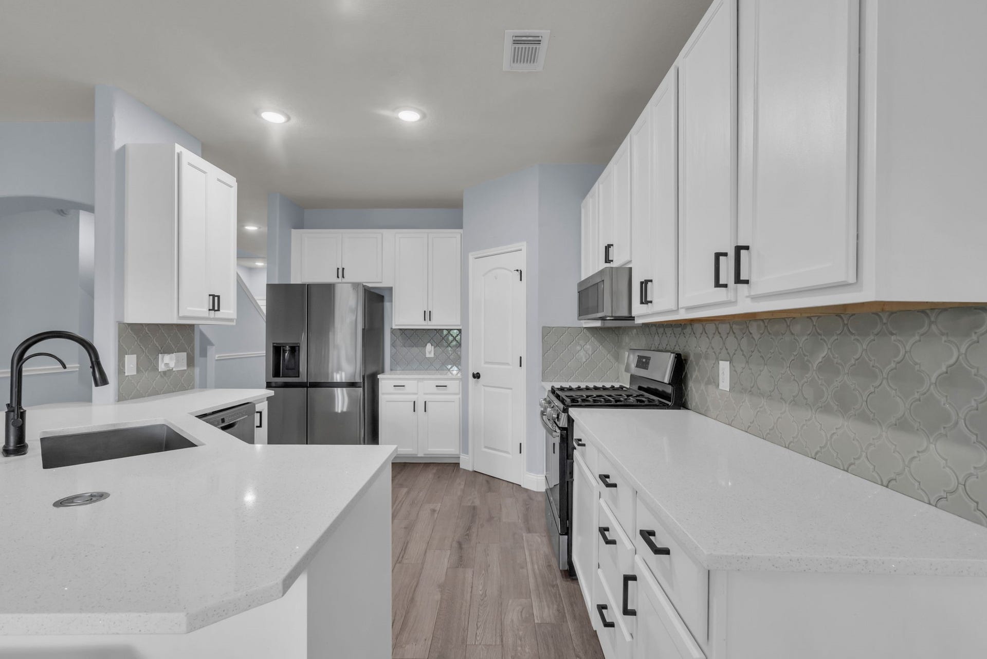 Remarkable kitchen features stainless steel appliances, ample cabinet space, modern backsplash, and a walk-in pantry. Refrigerator is included.