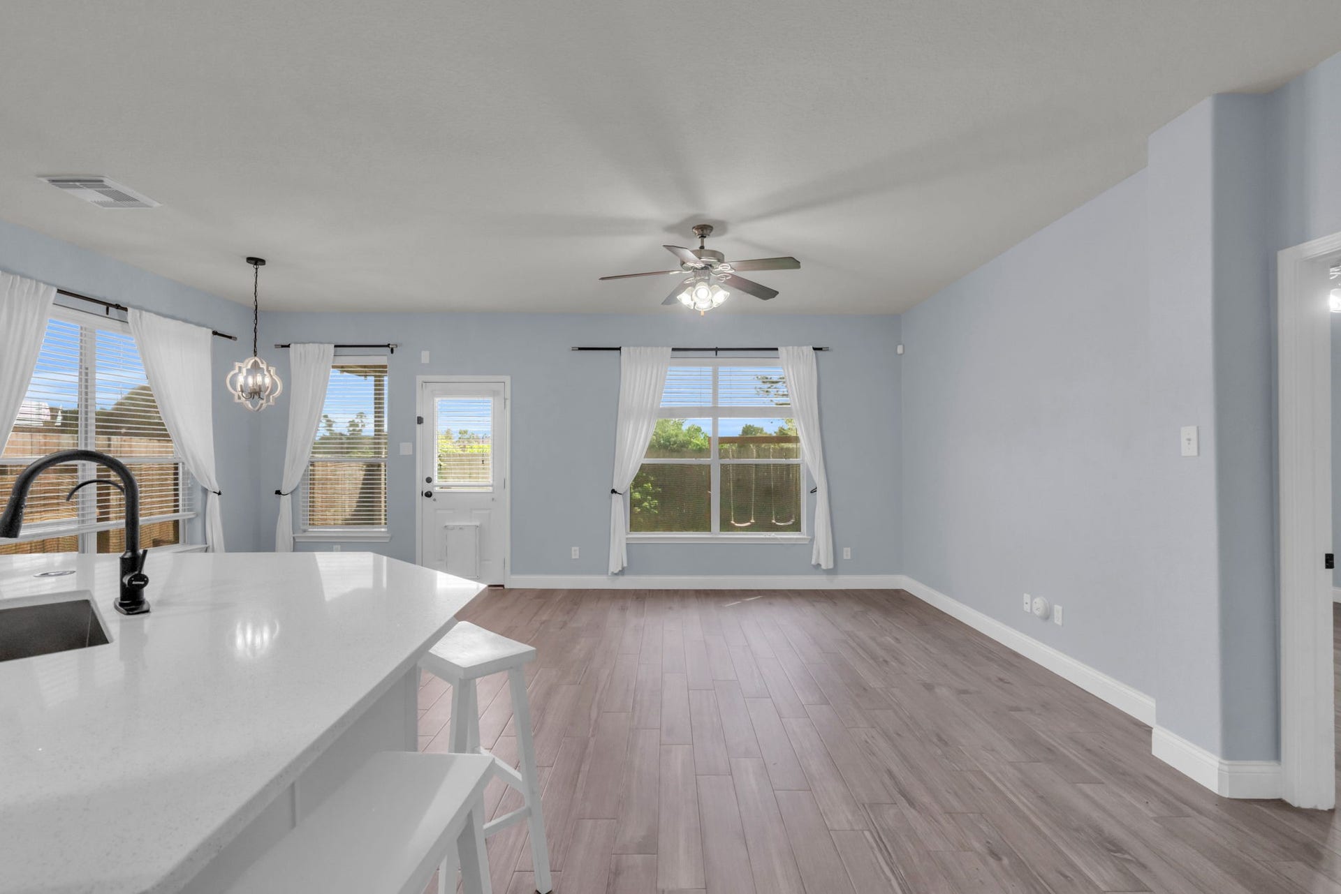 Open-concept living area flows seamlessly from the kitchen and breakfast bar, with abundant natural light and easy backyard access.