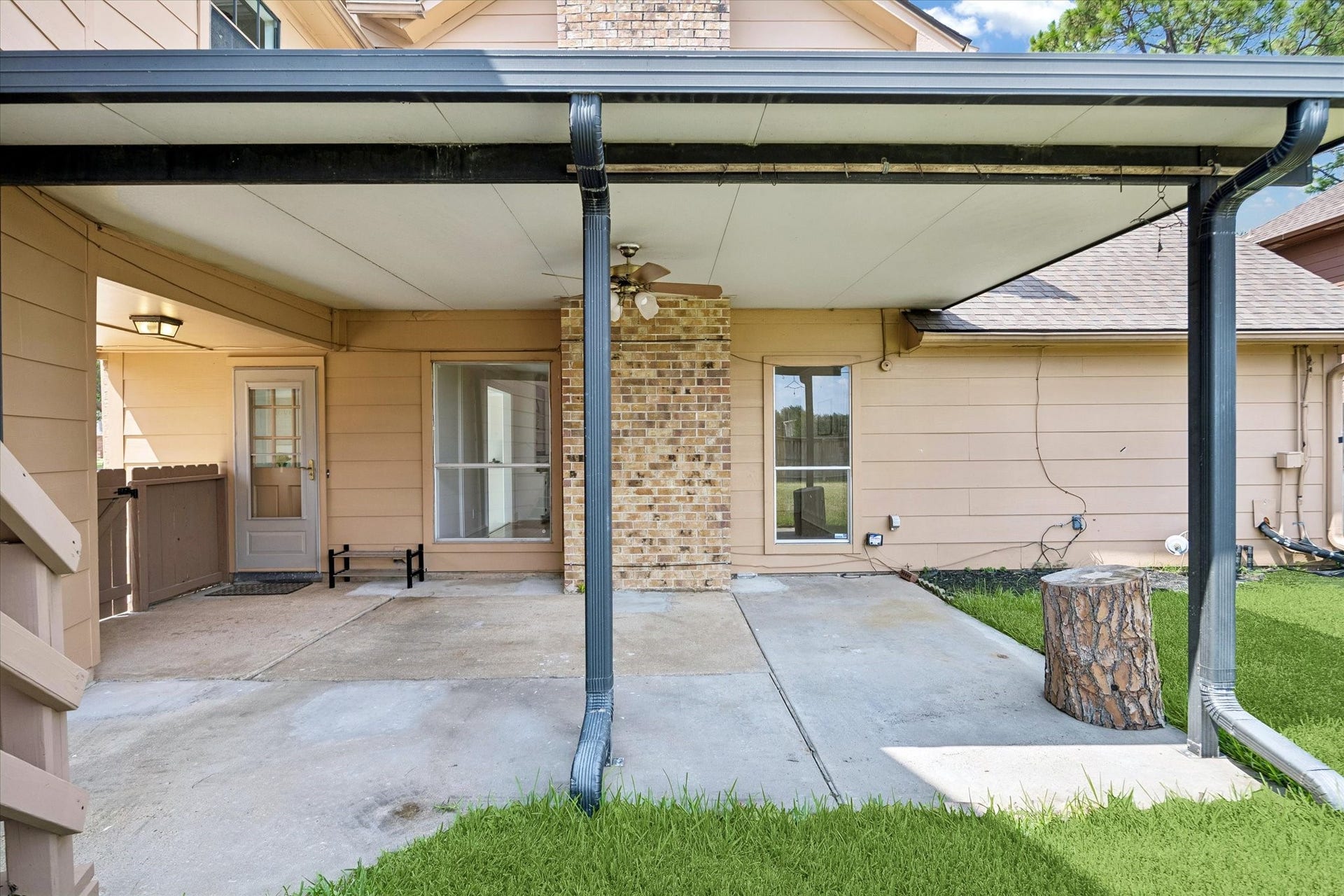 The covered patio with a ceiling fan, perfect for outdoor relaxation and entertaining.