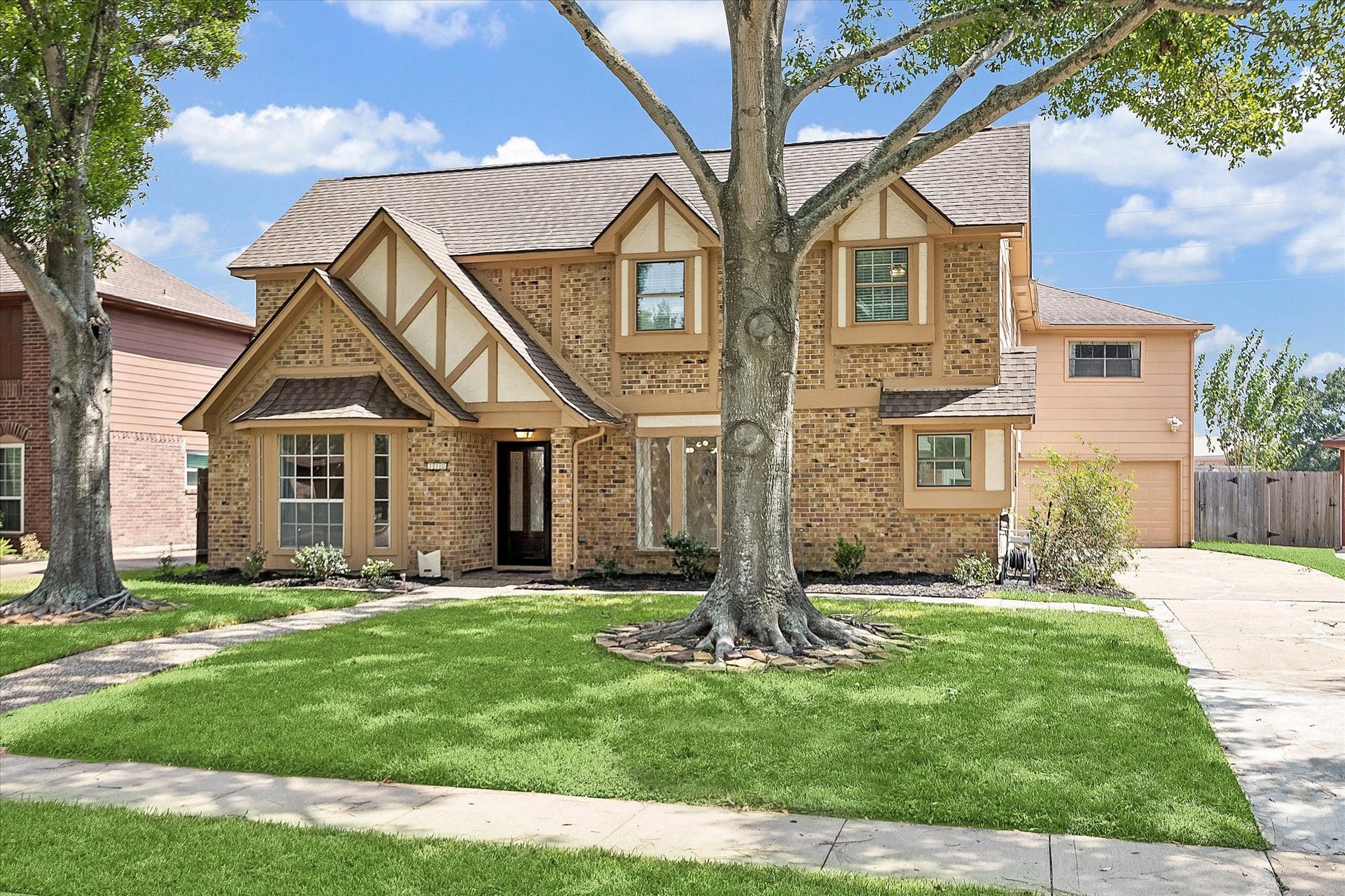 This charming two-story, several window home stands out with gorgeous Tudor accents surrounded by lush, green lawn with mature trees.