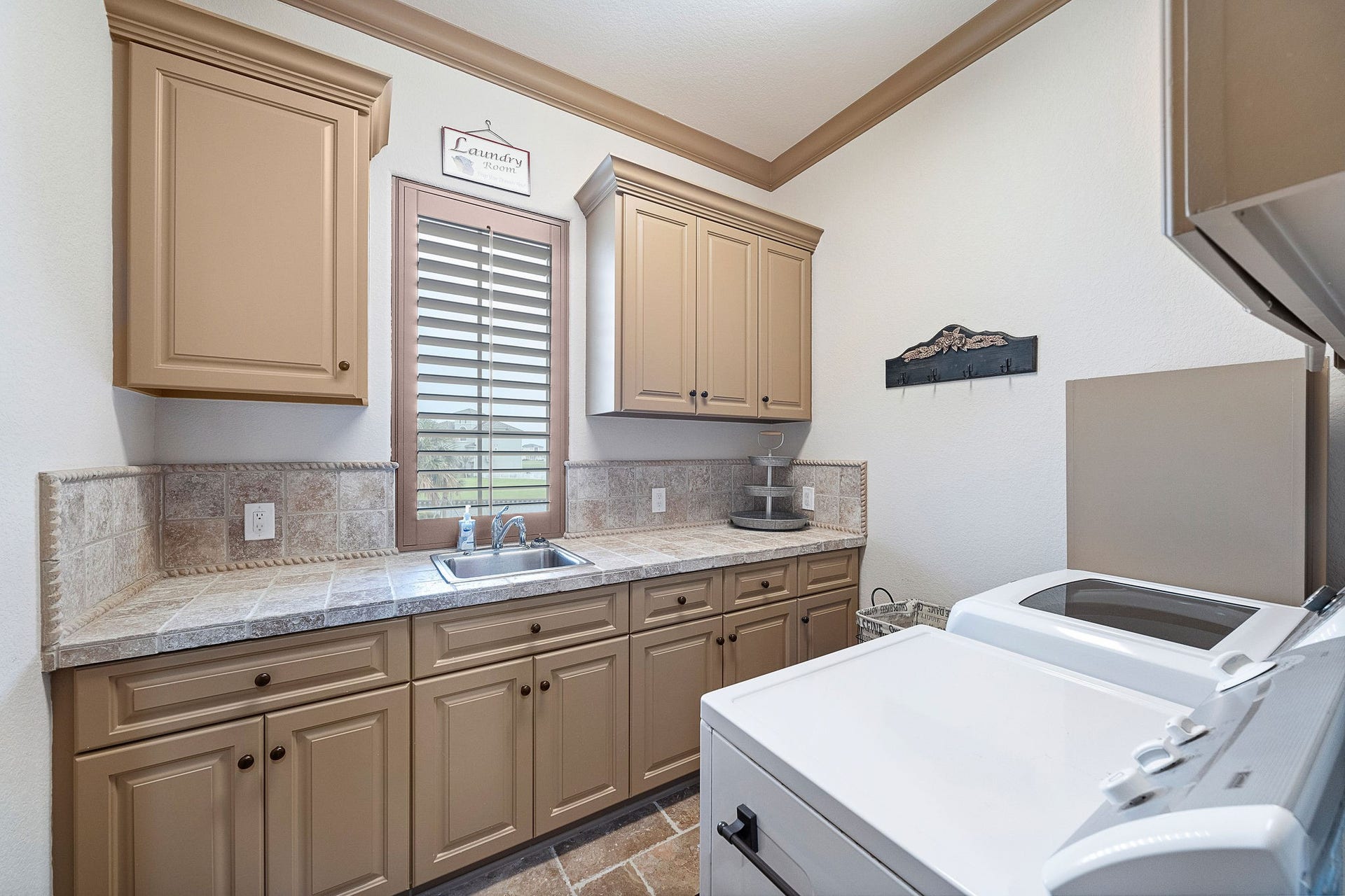21 Loggerhead, Hitchcock, TX 77563 The spacious utility room is designed for both functionality and ease, with ample storage and beautifully tiled counter space...and a waterfront view