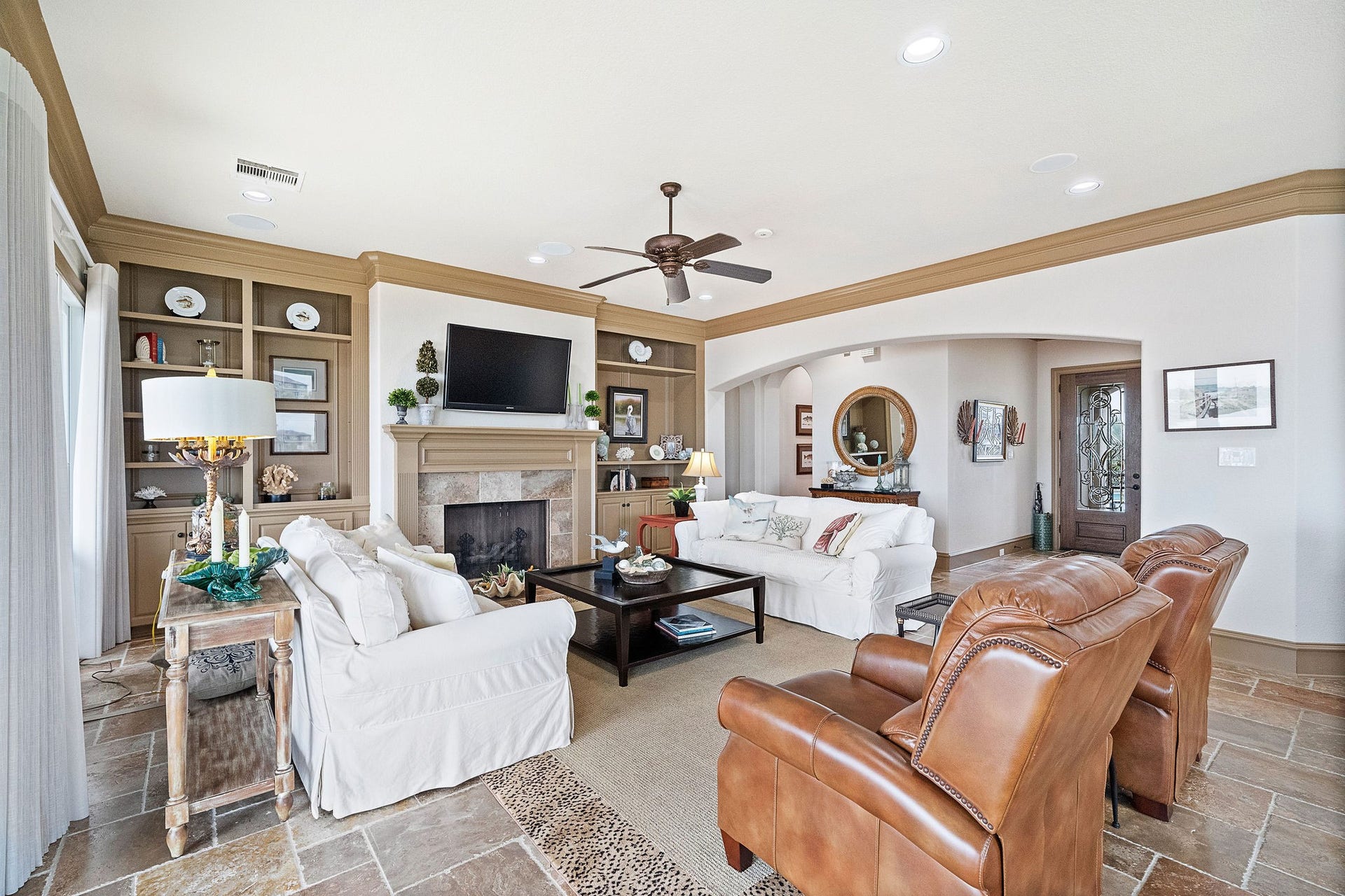 21 Loggerhead, Hitchcock, TX 77563 An open concept inviting living area, featuring a cozy fireplace, built-in cabinetry, and water views from every window throughout the home