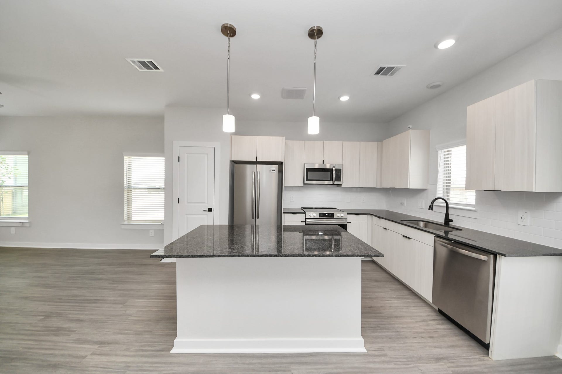 Boasting luxury finishes-stylish Island kitchen,granite counters,subway tile backsplash,ample custom cabinet space,stainless appliances,refrigerator,full size washer&dryer included,wood-like flooring throughout,open concept floor plan.