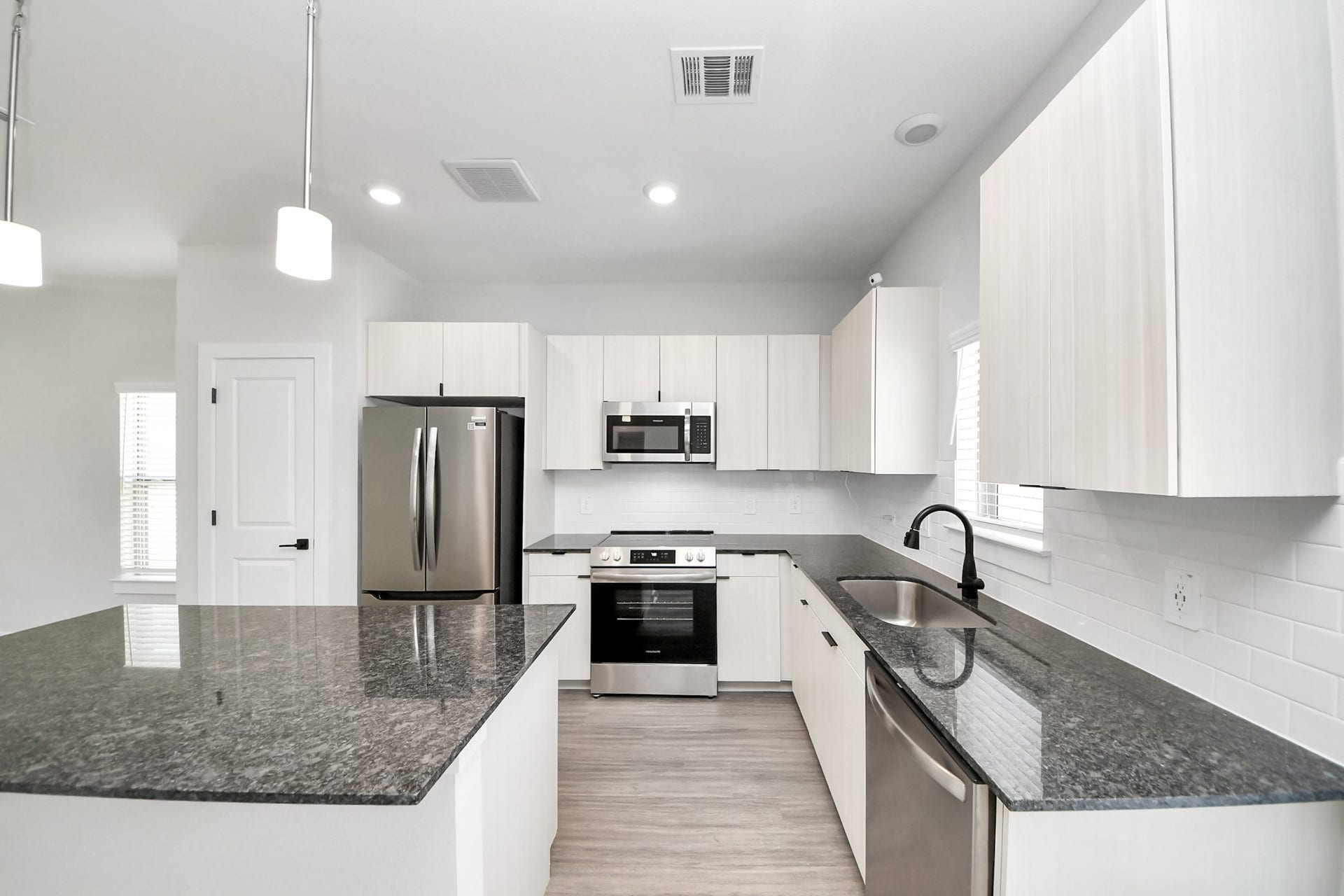 Boasting luxury finishes-stylish Island kitchen,granite counters,subway tile backsplash,ample custom cabinet space,stainless appliances,refrigerator,full size washer&dryer included,wood-like flooring throughout,open concept floor plan.