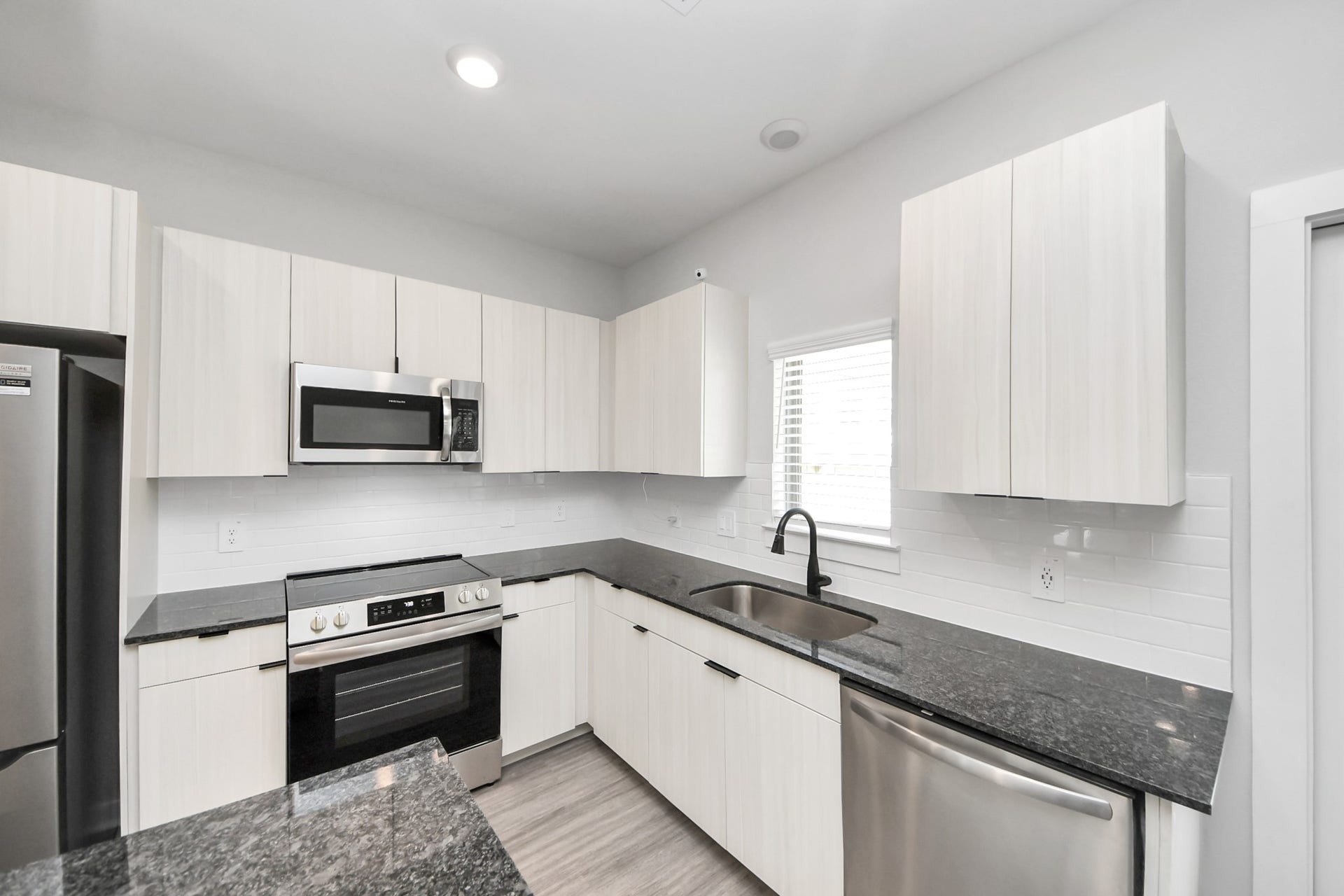 Boasting luxury finishes-stylish Island kitchen,granite counters,subway tile backsplash,ample custom cabinet space,stainless appliances,refrigerator,full size washer&dryer included,wood-like flooring throughout,open concept floor plan.