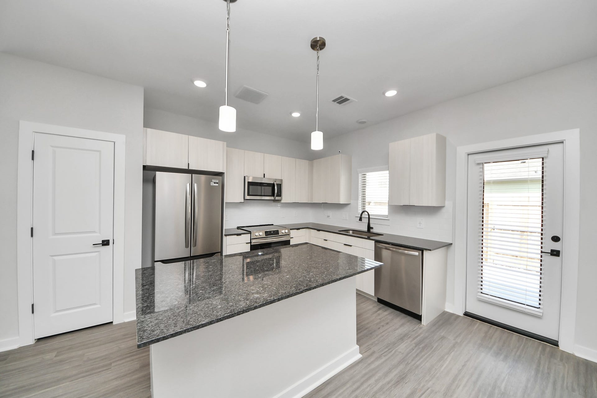 Boasting luxury finishes-stylish Island kitchen,granite counters,subway tile backsplash,ample custom cabinet space,stainless appliances,refrigerator,full size washer&dryer included,wood-like flooring throughout,open concept floor plan.