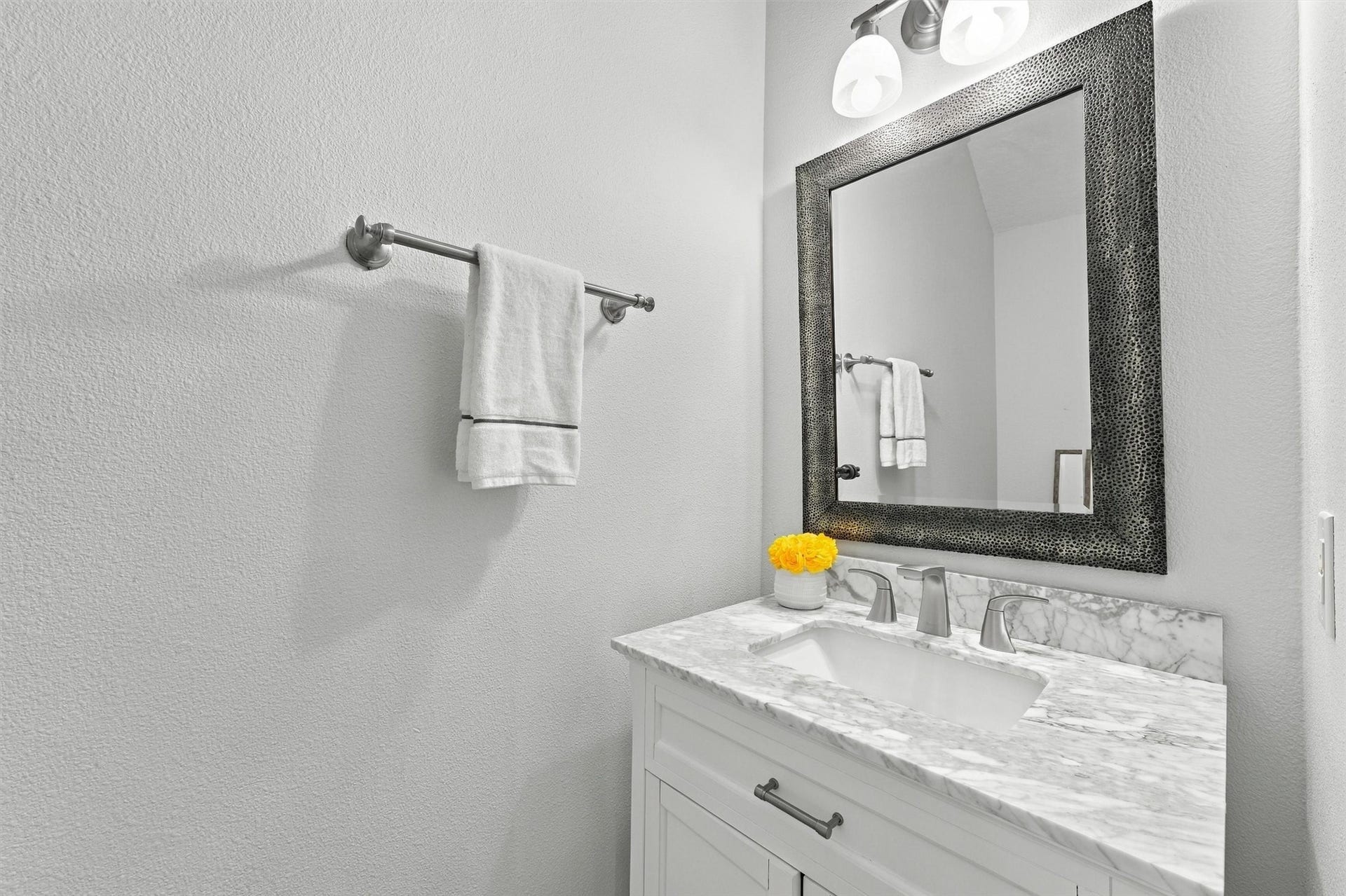 Convenient half bathroom featuring a pedestal sink and decorative mirror.