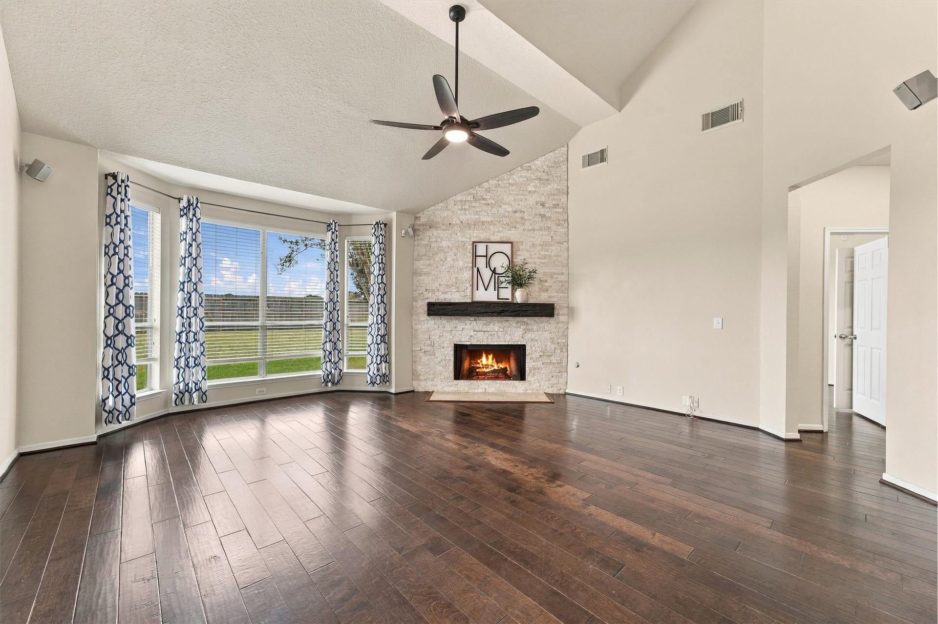 Another view of the family room highlighting the beautiful fireplace and large windows.