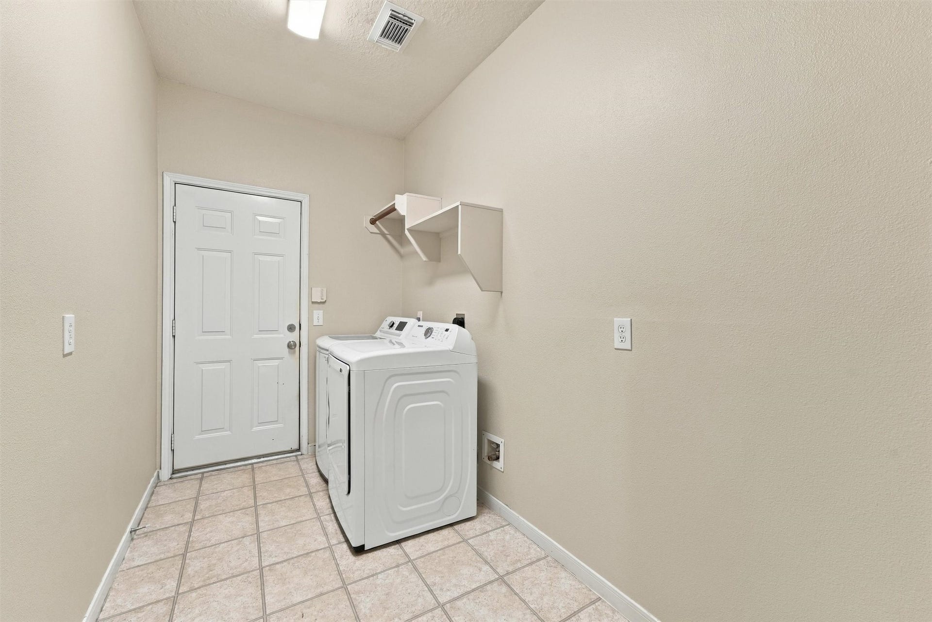 Interior utility room with included washer and dryer for added convenience.