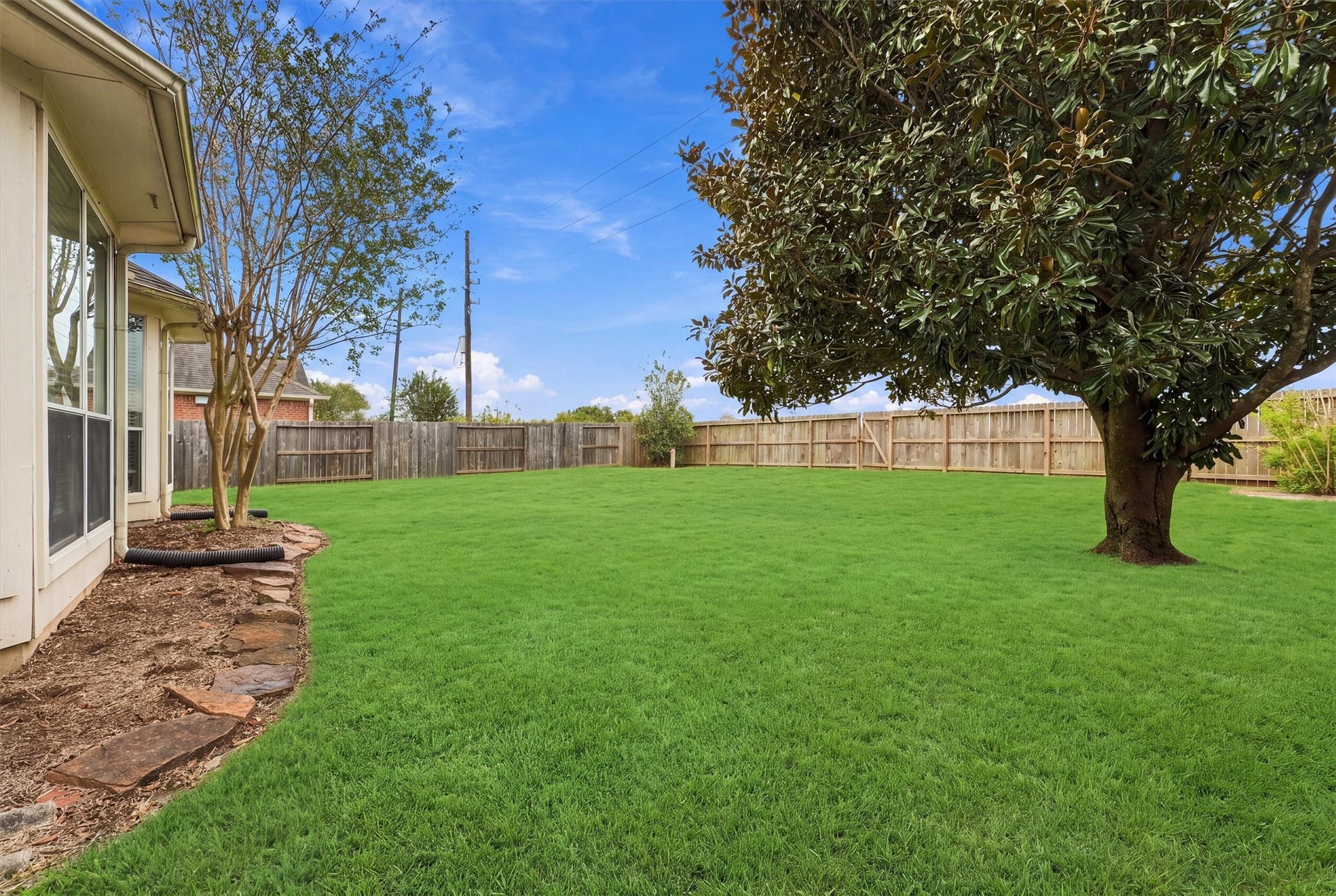 Beautiful backyard featuring mature trees and plenty of room for outdoor enjoyment.