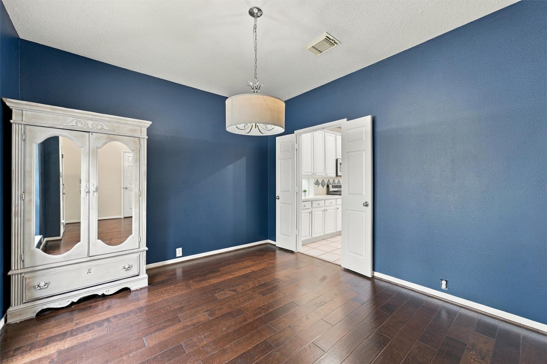 Another view of the formal dining room with beautiful natural light and rich hardwood flooring.