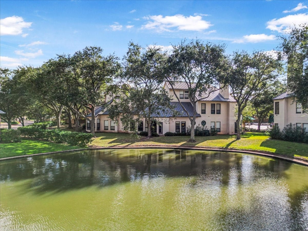4144 Greystone Way, #101, Sugar Land, TX 77479 This photo showcases what you could walk daily, nestled among mature trees and overlooking a tranquil lake. The serene setting features lush greenery and a well-maintained landscape, providing a peaceful and picturesque environment.