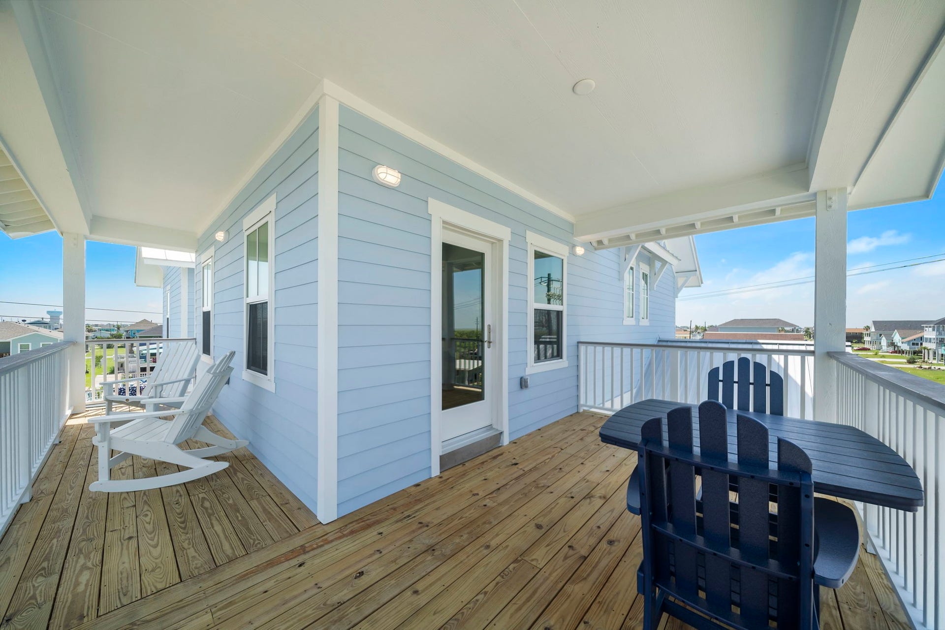 Charming wraparound porch with elegant white railings and inviting seating, perfect for enjoying the scenic views and outdoor relaxation.