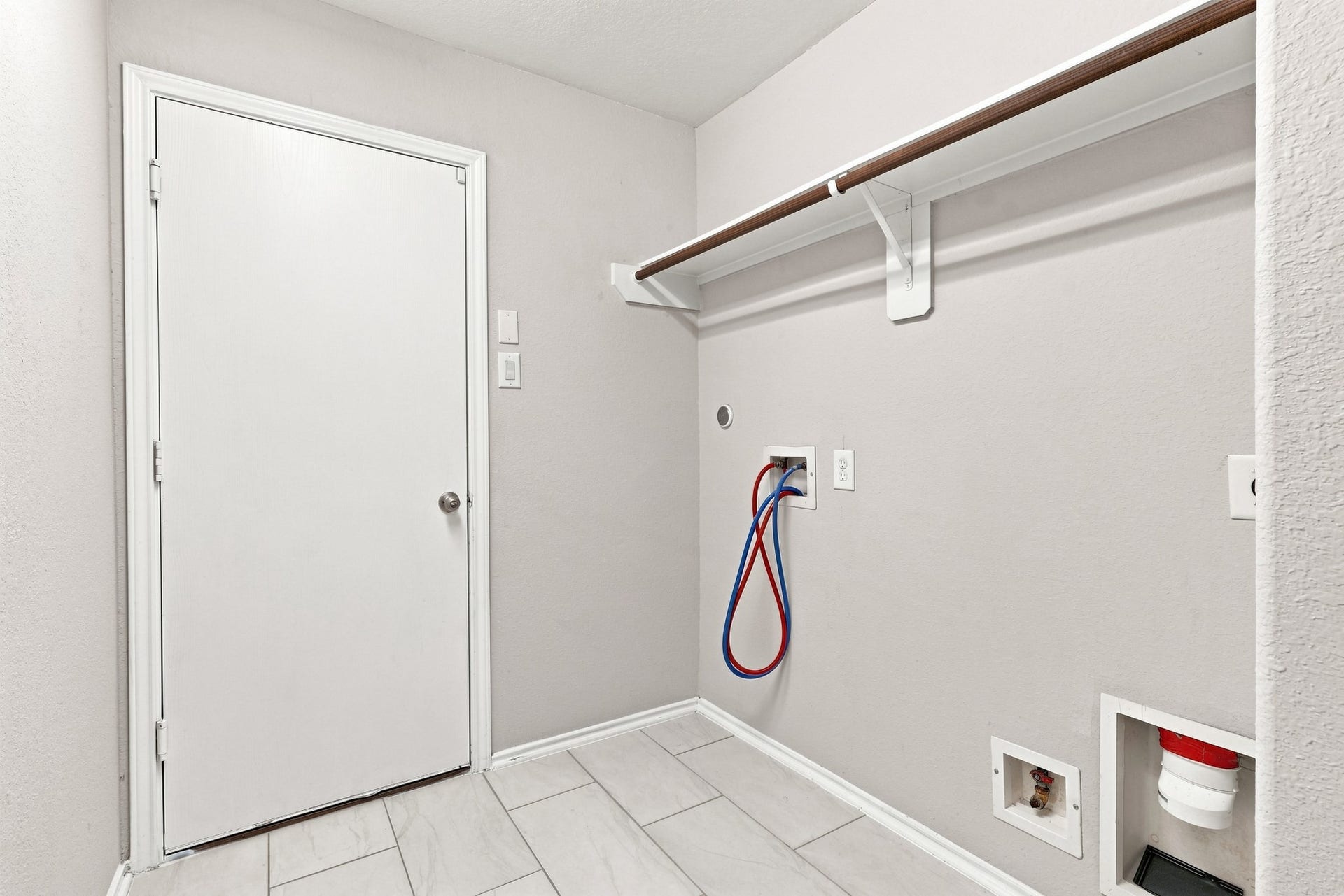 Interior utility room with washer and dryer connections and built-in hanging/storage space.