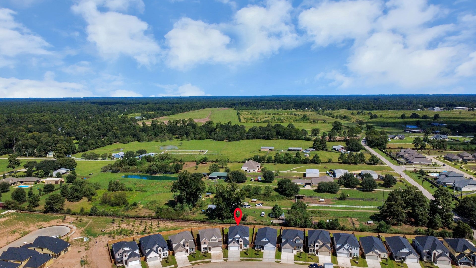 An aerial view of a spacious subdivision lot, highlighting a well-maintained yard and a fully fenced perimeter, offering both privacy and expansive outdoor space.
