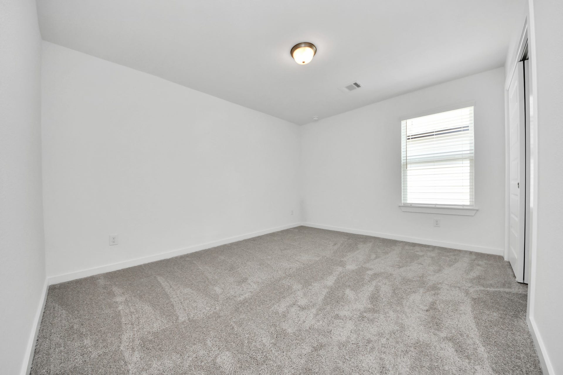 Secondary bedroom features plush carpeting, large windows that let in plenty of natural light, bright paint, and spacious closets. Sample photo of completed home with similar floor plan. Actual colors and selections may vary.