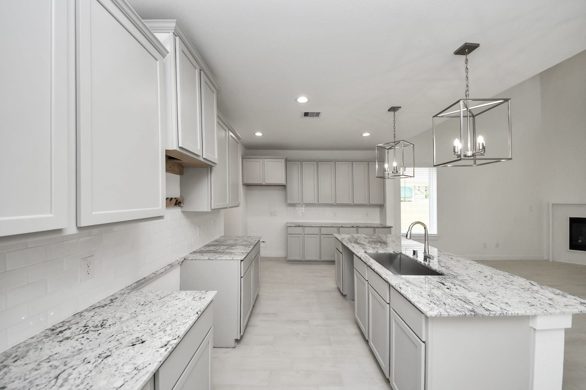 This generously spacious kitchen is a dream realized! With a massive granite island, high ceilings, soft close cabinets, granite countertops, stainless steel appliances, a sleek tile backsplash, recessed lighting, and an extended counter area, it offers both style and practicality. All this opens up to the expansive family room, creating a perfect hub for gatherings.