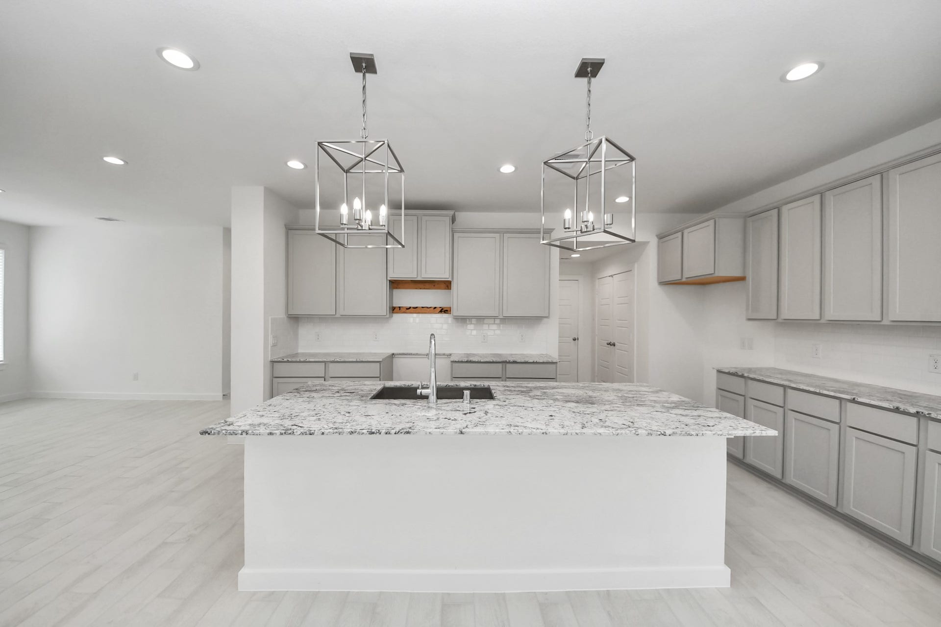 This kitchen is by far any chefs dream! This spacious kitchen features high ceilings, stained wood cabinets, granite countertop, SS appliances, modern tile backsplash, recessed lighting, extended counter space, granite kitchen island with double sink, and space for breakfast bar, and a walk-in pantry all overlooking your huge family room.