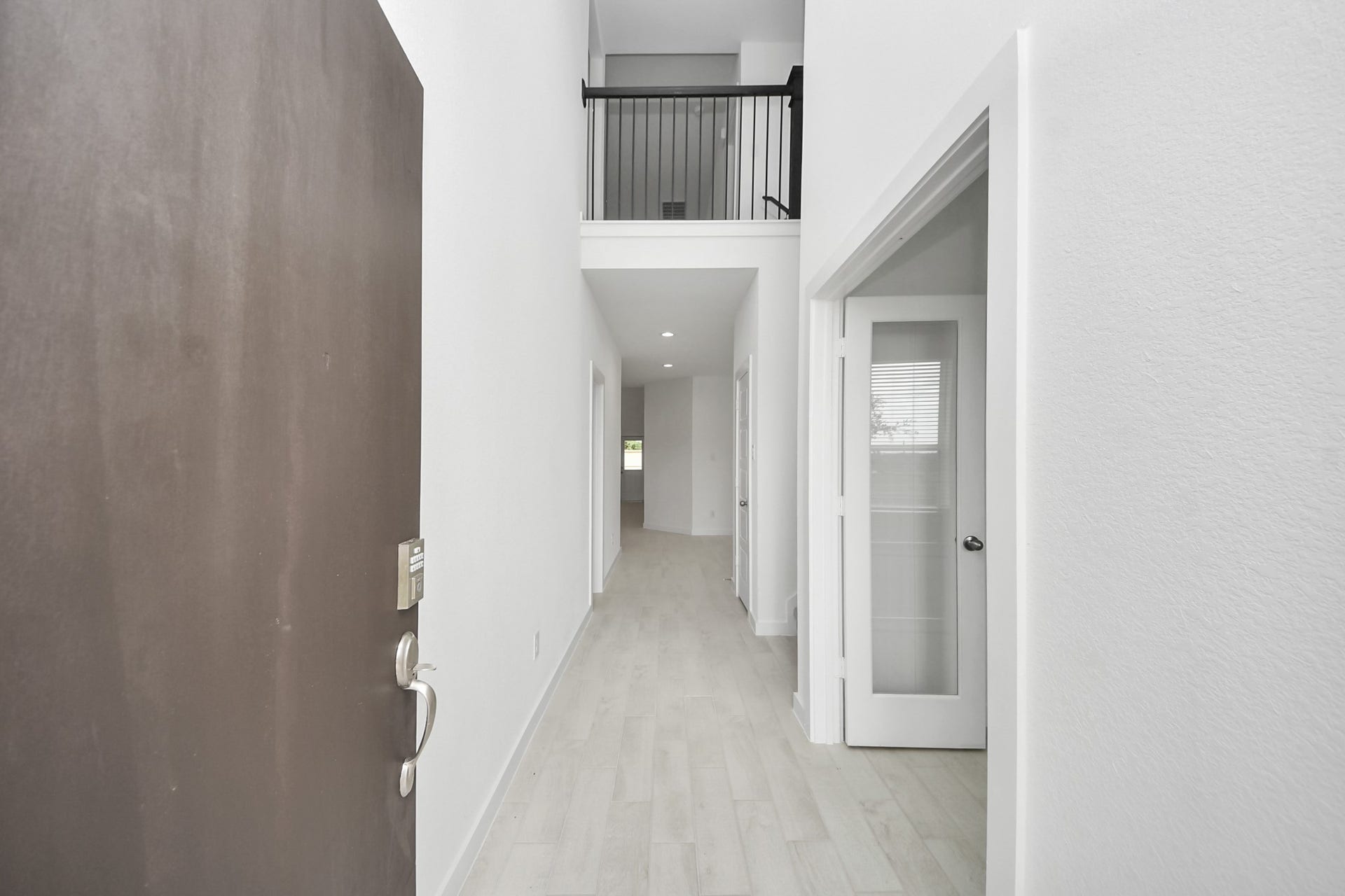 As you step into the threshold of this luxurious home, you'll soon be welcomed by an elegant glass door (to be installed). Inside, soaring ceilings amplify the spaciousness, while the refined wood-look tile flooring and oversized baseboards exude sophistication and charm.