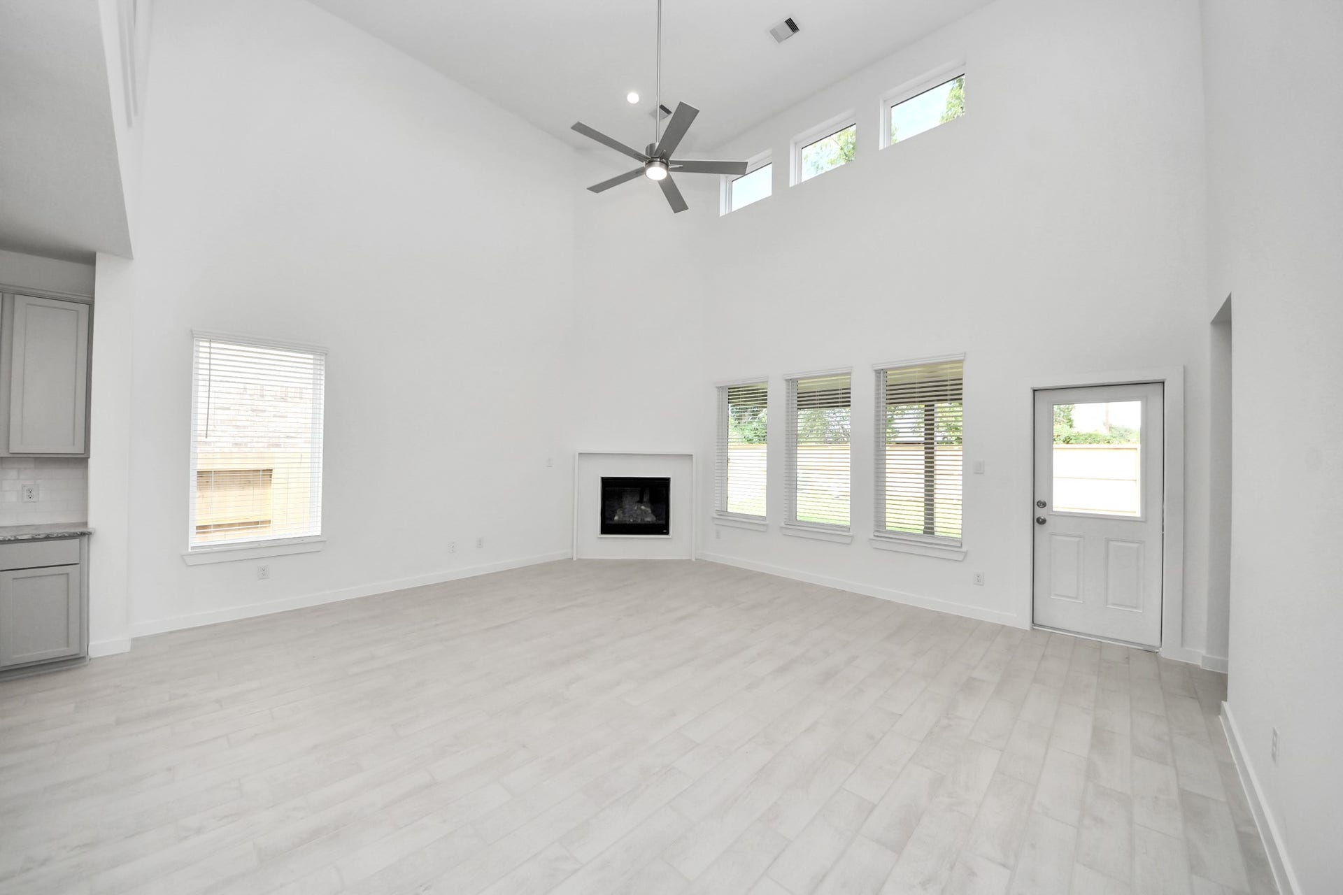 Family room flooded with natural light through the expansive windows.  The premium tile flooring adds a touch of luxury to the space, creating the perfect setting for relaxing moments and cherished gatherings with loved ones
