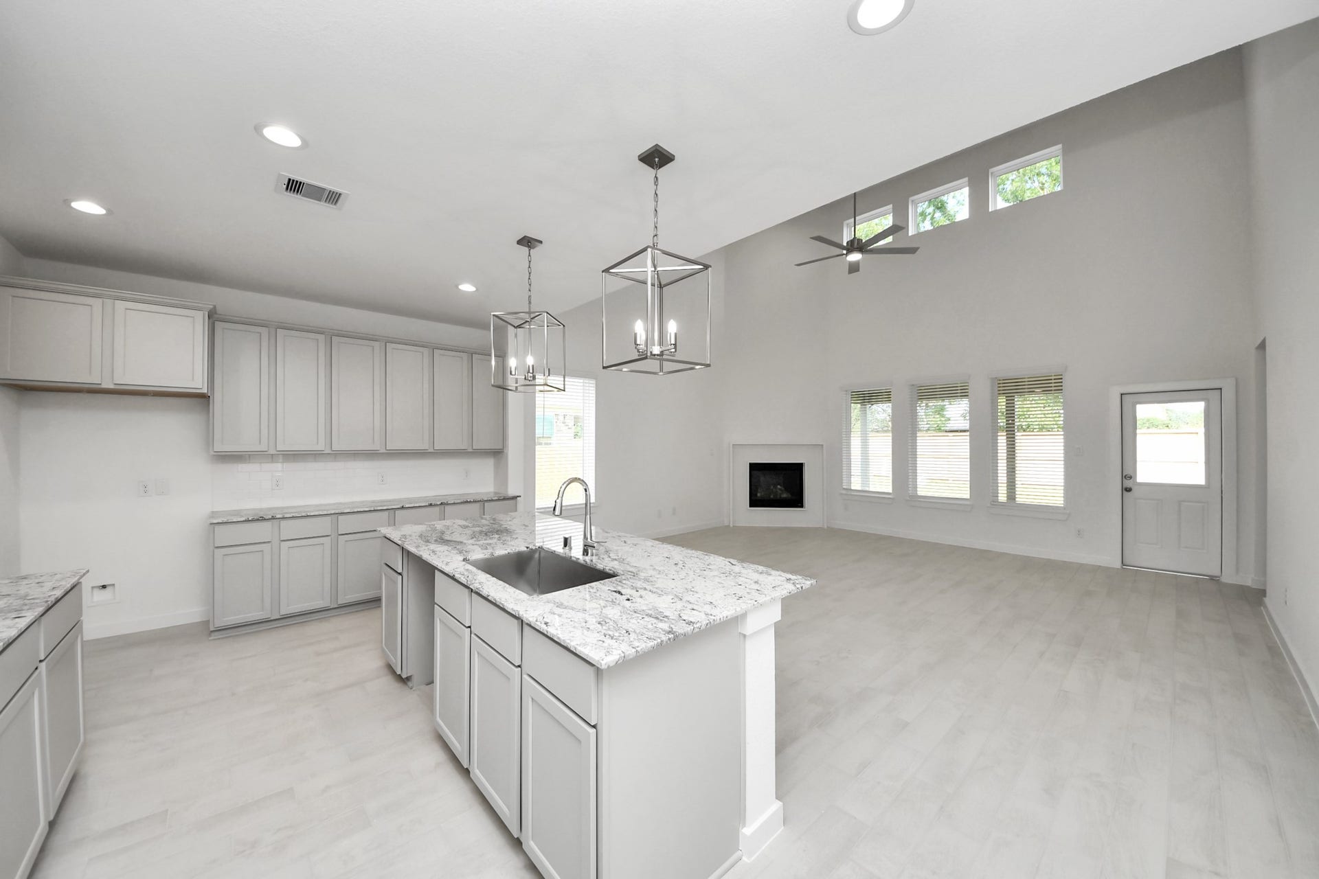 Step into a dream realized with this generously spacious kitchen! A massive granite island takes center stage, complemented by high ceilings and soft-close cabinets. The granite countertops, stainless steel appliances, sleek tile backsplash, and recessed lighting complete the elegant design.