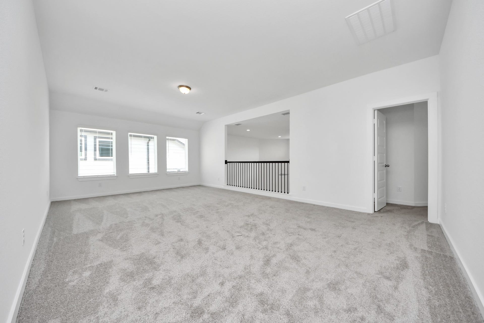 Come upstairs and enjoy a day of leisure in this fabulous game room! This is the perfect hangout spot or adult game room! Features plush carpet, high ceilings, custom paint and windows for plenty of natural light. Sample photo of completed home with similar floor plan. Actual colors and selections may vary.