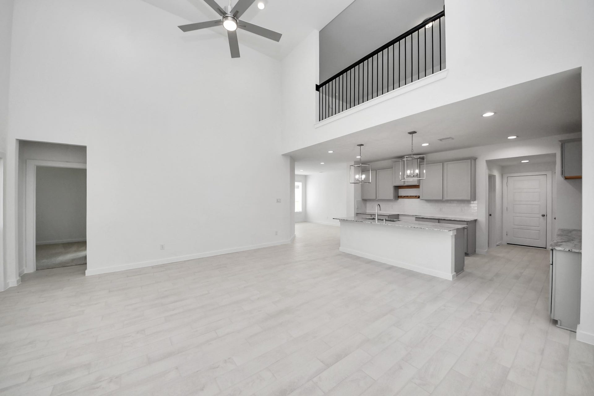 Welcome family and guests to your charming living room! With its high ceilings, recessed lighting, ceiling fan, custom paint, beautiful flooring, and large windows that let in abundant natural light, this room is perfect for gatherings.