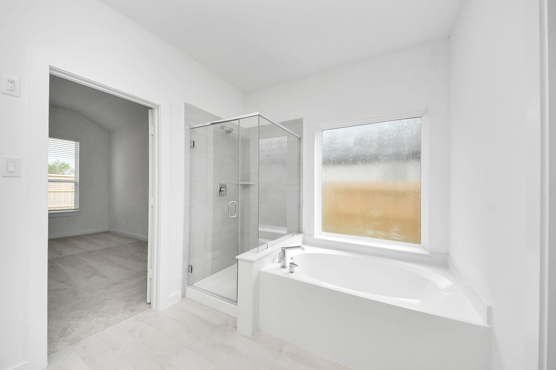 Indulge in a spa-like retreat within the confines of this primary bathroom. Delight in a spacious walk-in shower enveloped in stylish tile surround, unwind in a separate garden tub adorned with custom detailing.