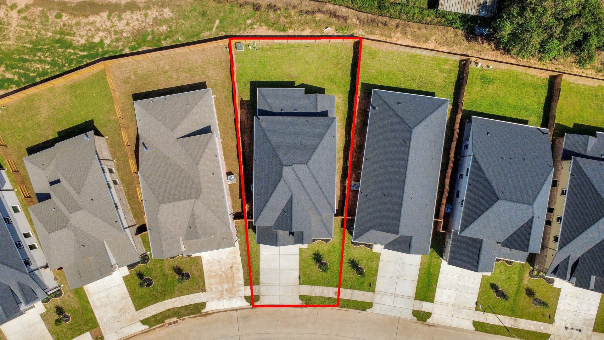 An aerial view of a spacious subdivision lot, highlighting a well-maintained yard and a fully fenced perimeter, offering both privacy and expansive outdoor space.