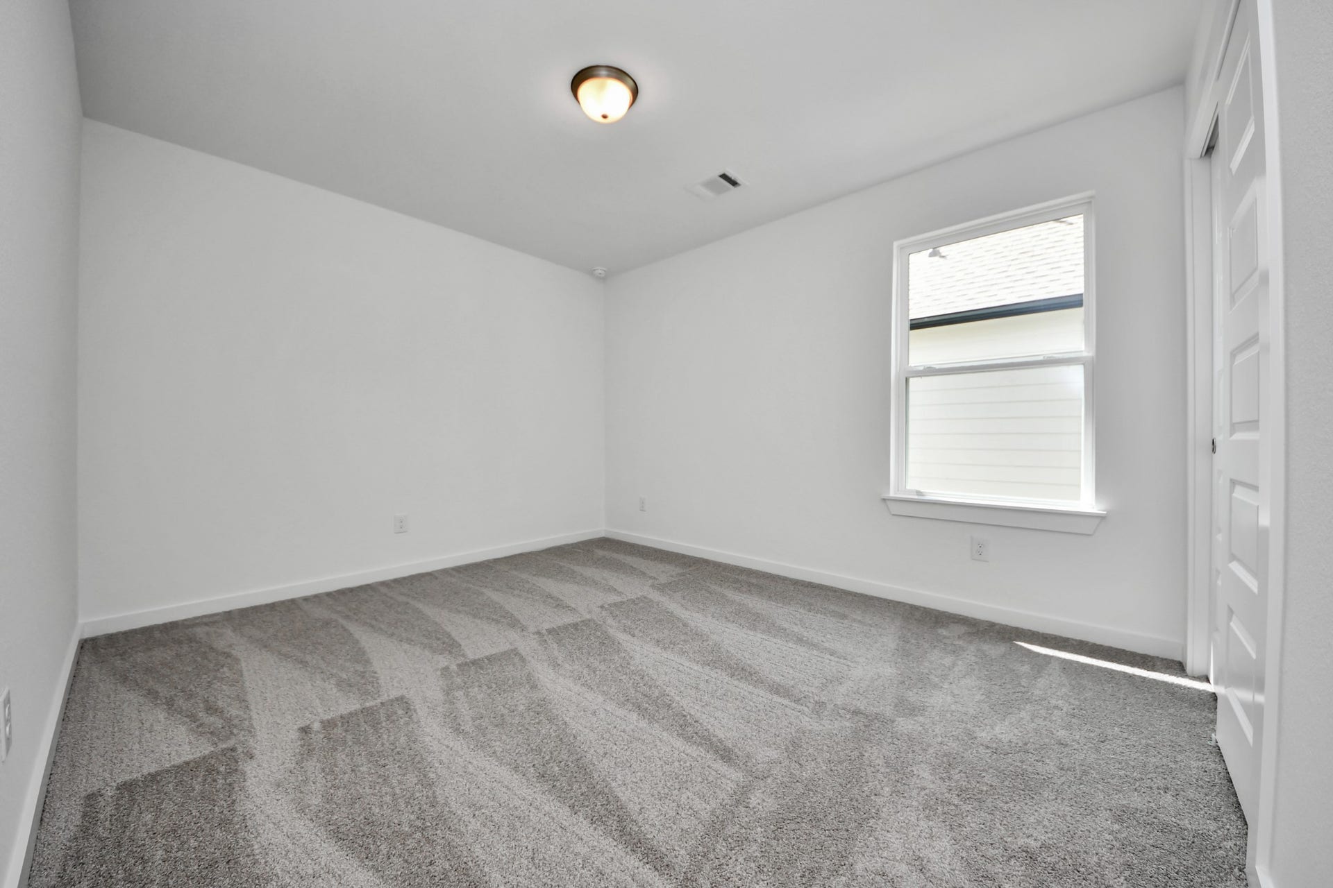 Secondary bedroom features plush carpeting, large windows that let in plenty of natural light, bright paint, and spacious closets. Sample photo of completed home with similar floor plan. Actual colors and selections may vary.