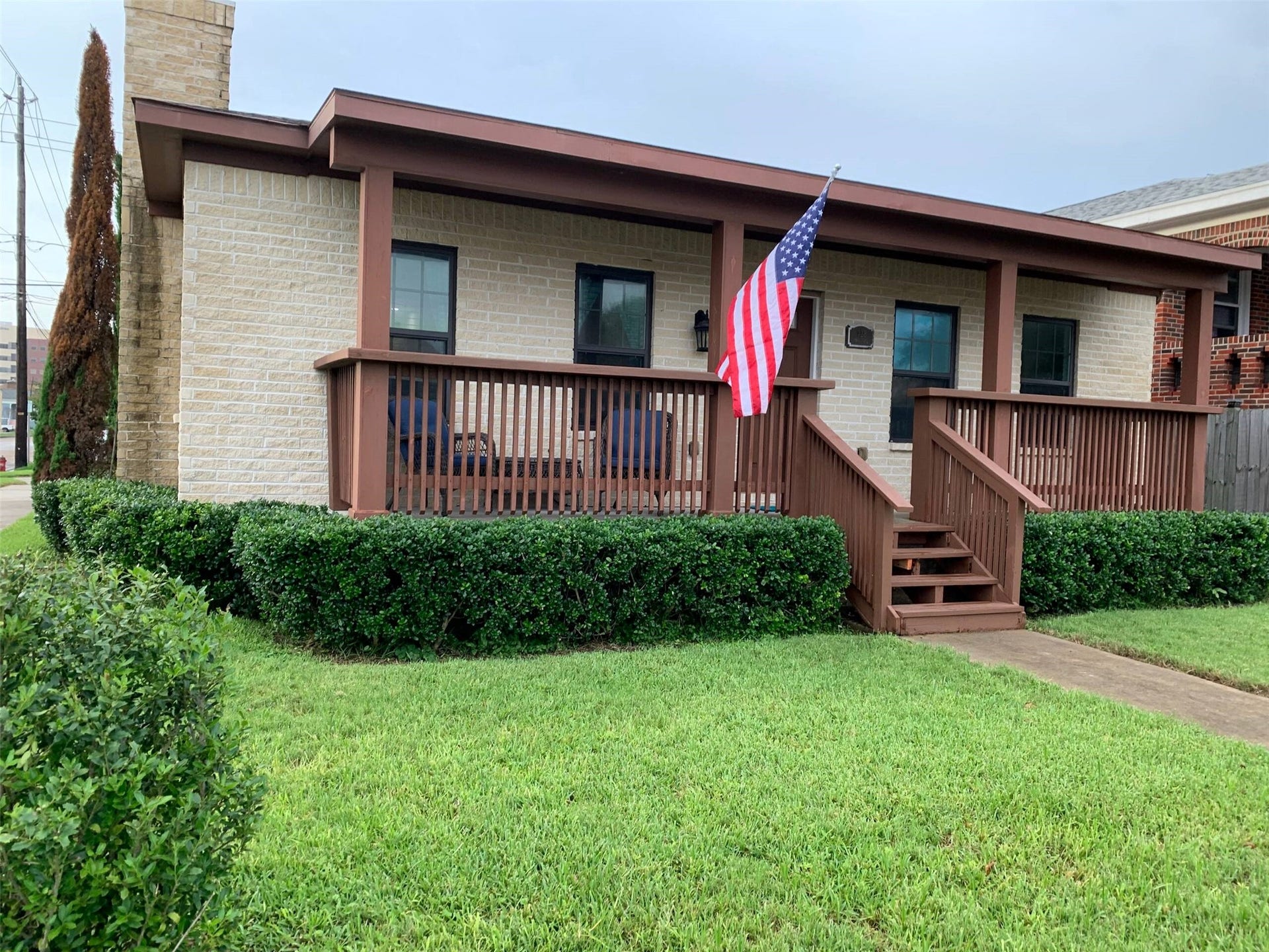 Charming single-story home with a cozy front porch, well-maintained landscaping, and classic brick accents, perfect for relaxing or greeting neighbors.