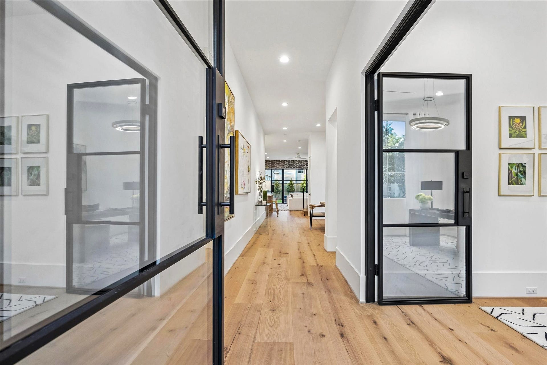 [Entry] The open floorplan provides spacious, light-filled, seamlessly-integrated rooms. This view travels from the entry hall into the dining and great room.