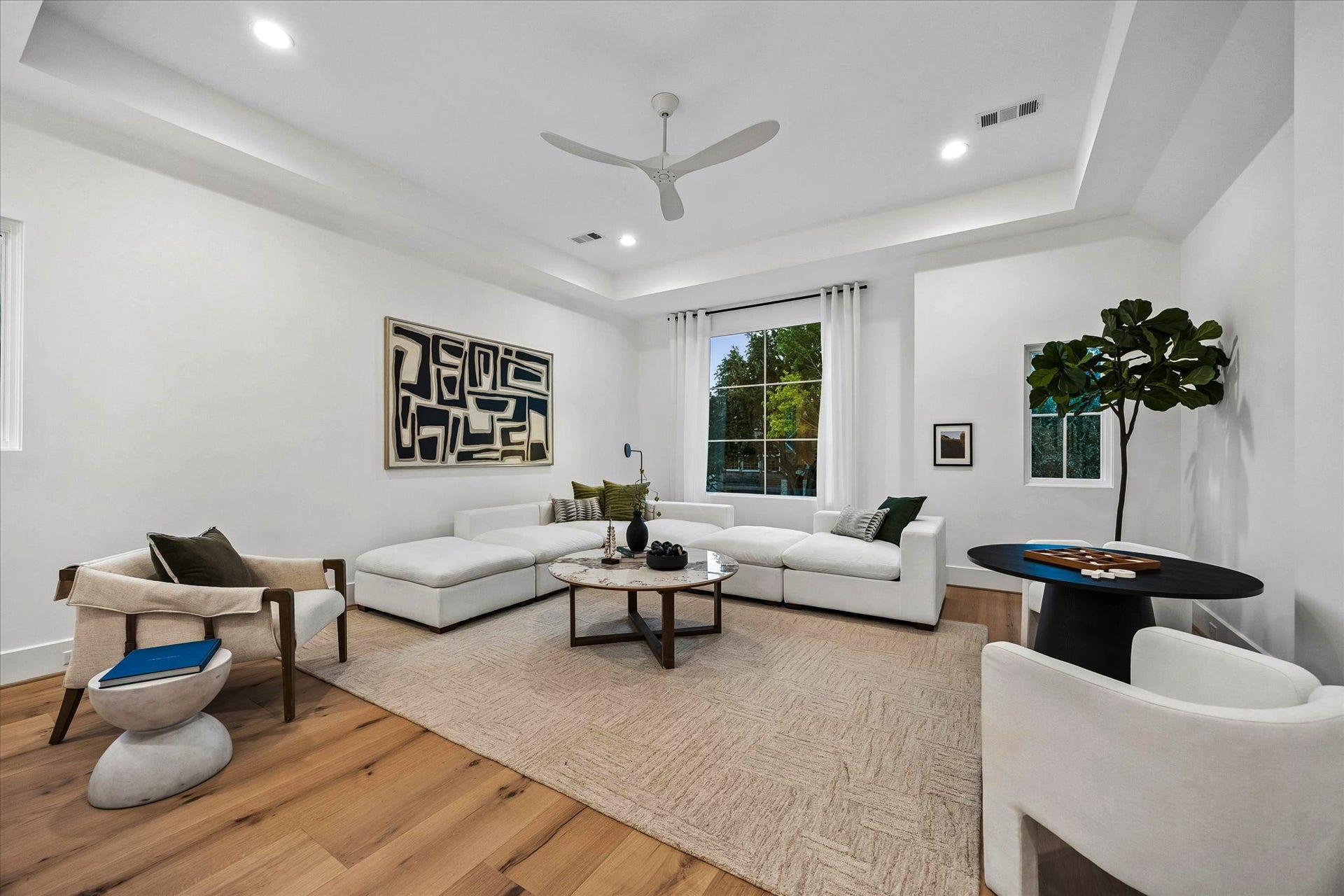 [Game Room] Gameroom with treetop views. The perfect balance between comfort, function, and beauty. This light-filled gameroom is where family and guests can hang out comfortably and upkeep is effortless.
