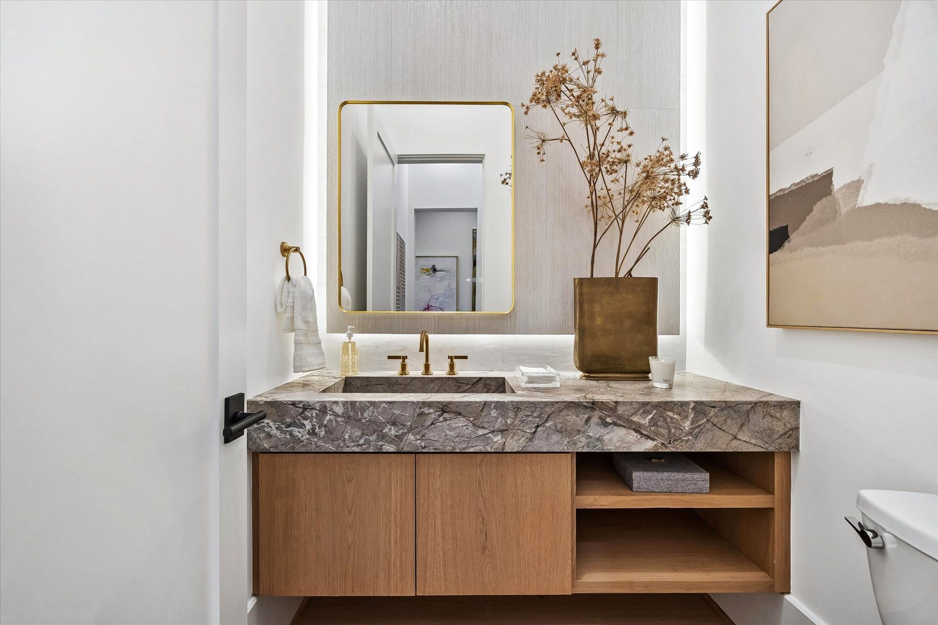 [Powder Room] Sleek floating vanity with integrated stone sink.